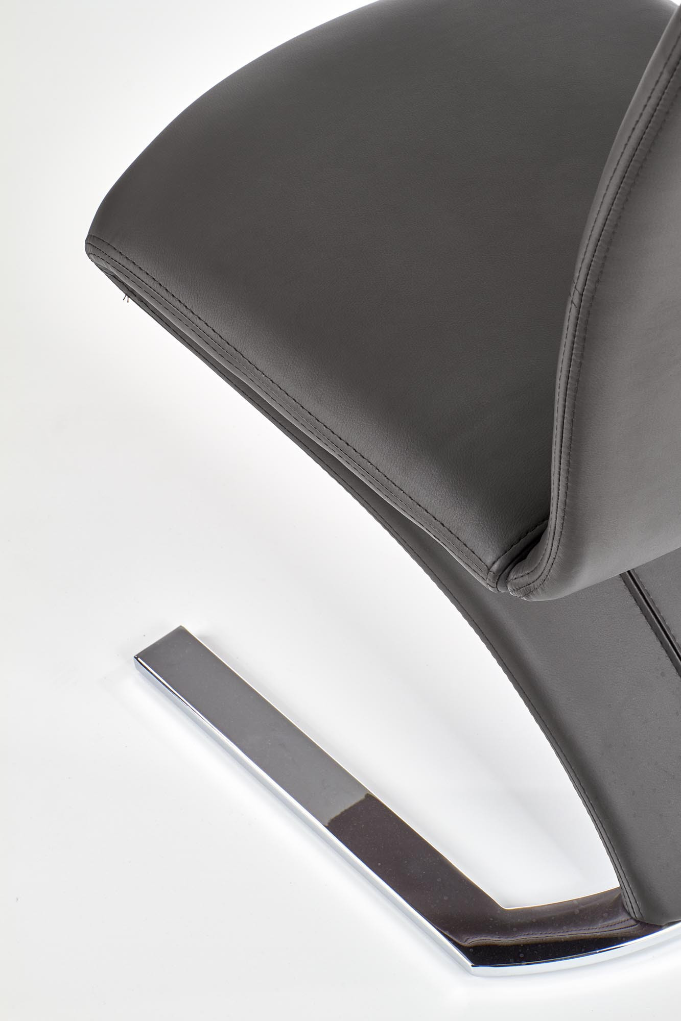 Zbliżenie na czarne krzesło K188 z eco skóry na chromowanej podstawie.