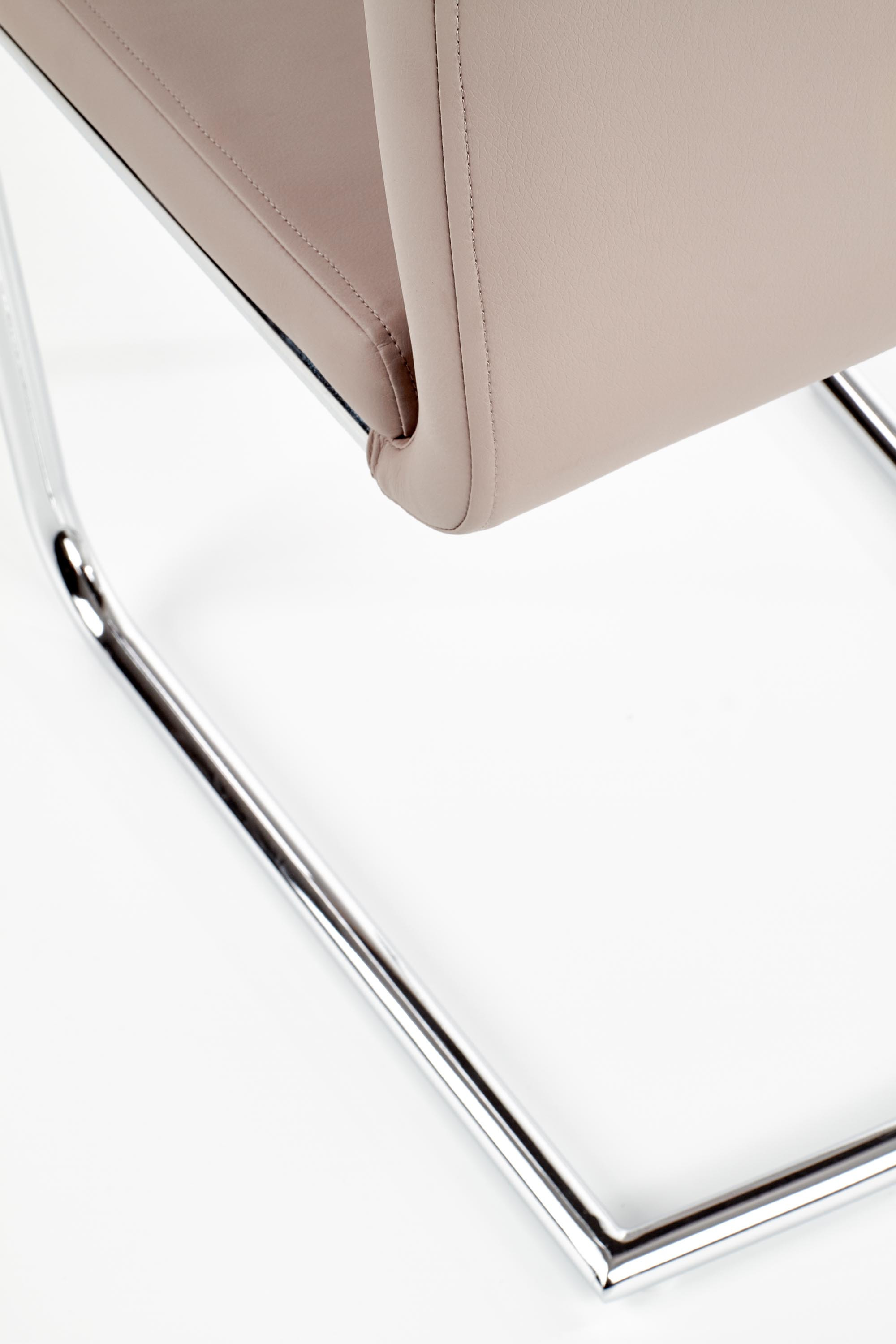 Zbliżenie na chromowaną stalową ramę i cappuccino eco skórę krzesła K224.