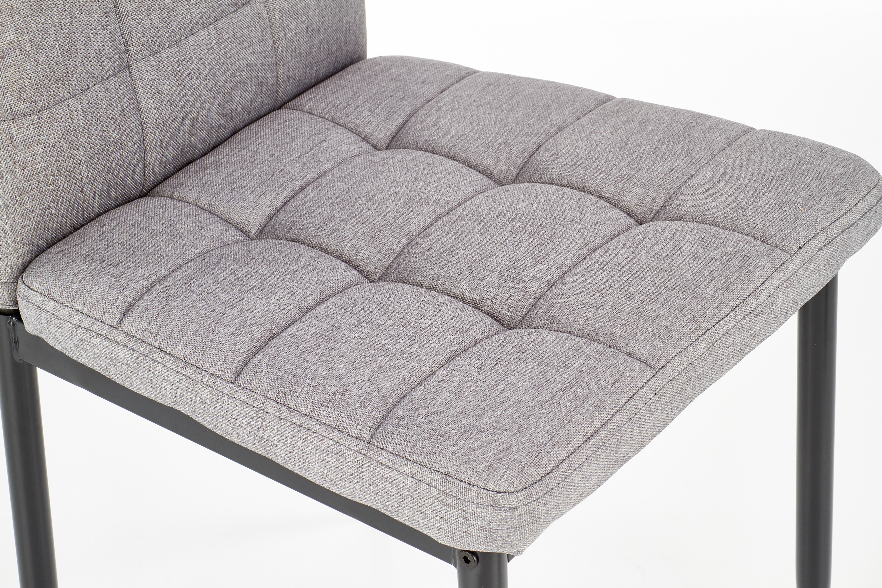 Zbliżenie na siedzisko krzesła K292 z popielatej pikowanej tkaniny.