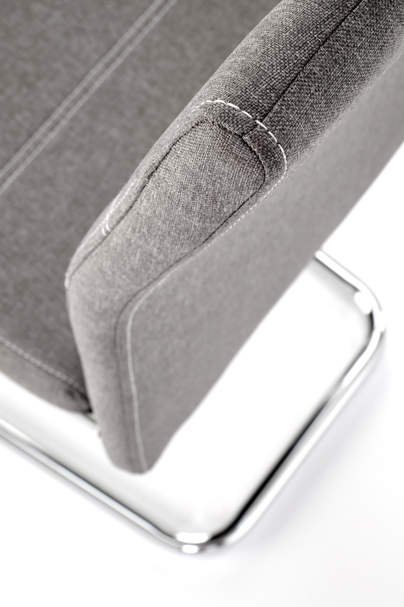 Zbliżenie na popielate krzesło K349 na chromowanych płozach, ukazujące detal tapicerowanego oparcia.