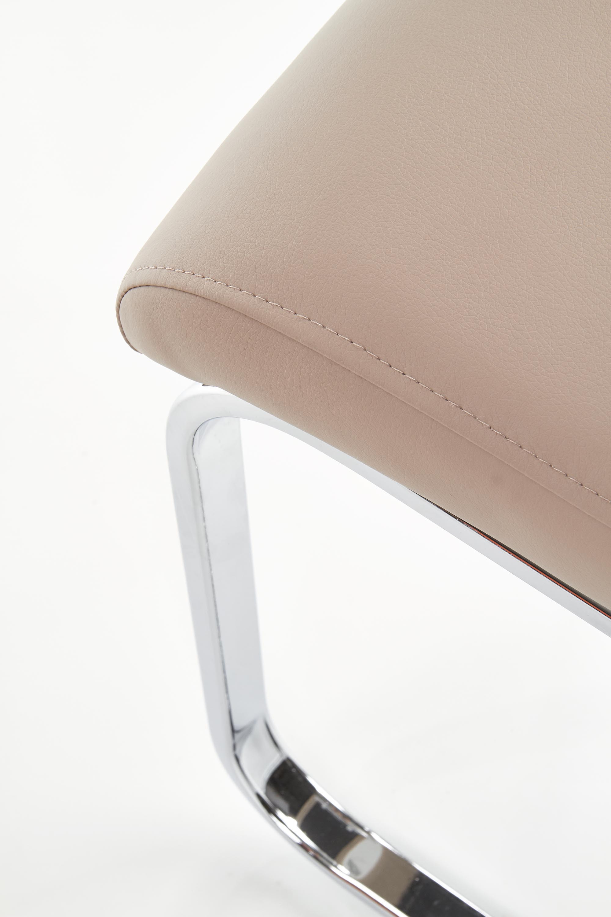 Zbliżenie na chromowaną podstawę i cappuccino siedzisko krzesła K85 z eco skóry.