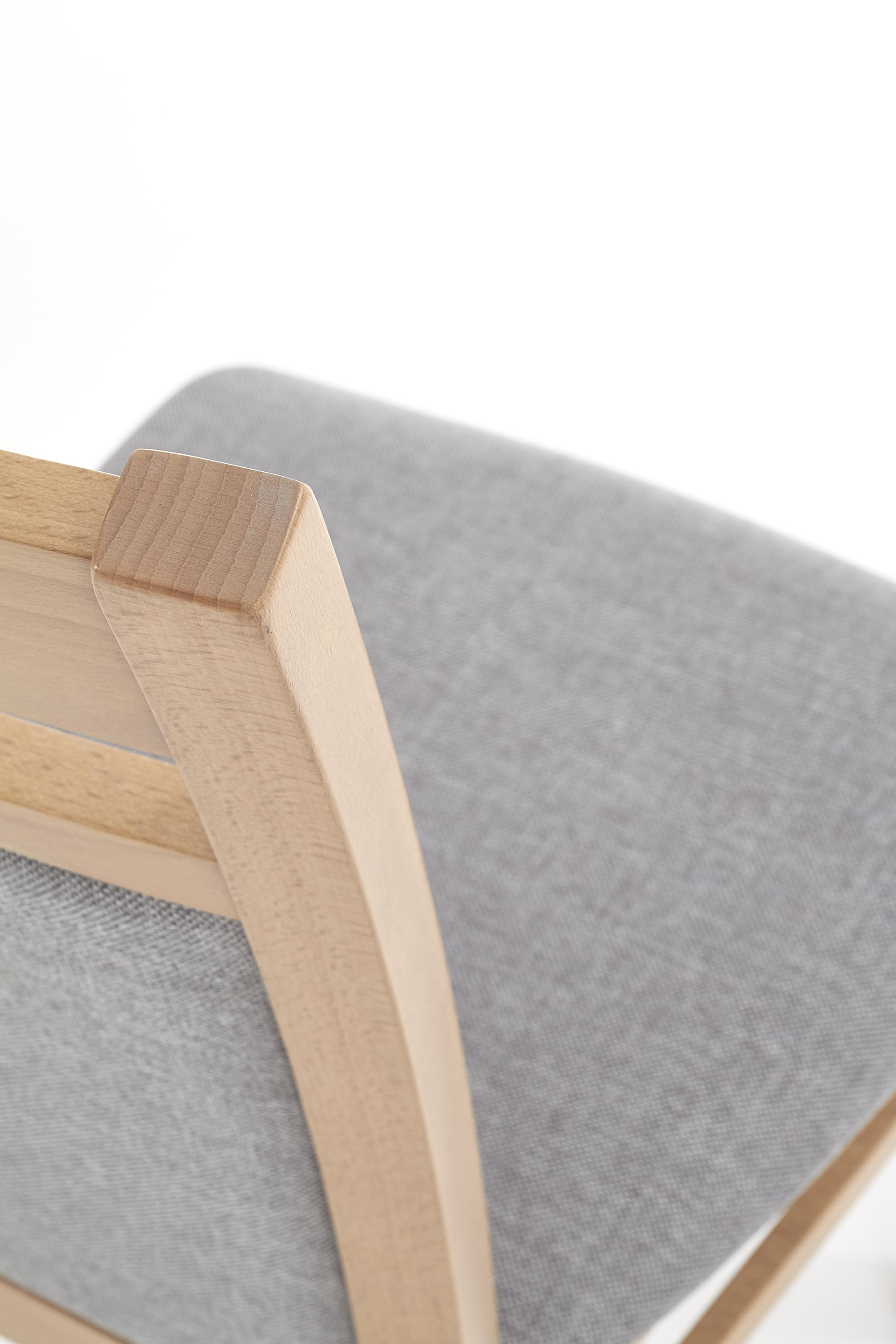 Zbliżenie na szare tapicerowane oparcie i drewnianą ramę krzesła GERARD 2 z miodowego dębu.