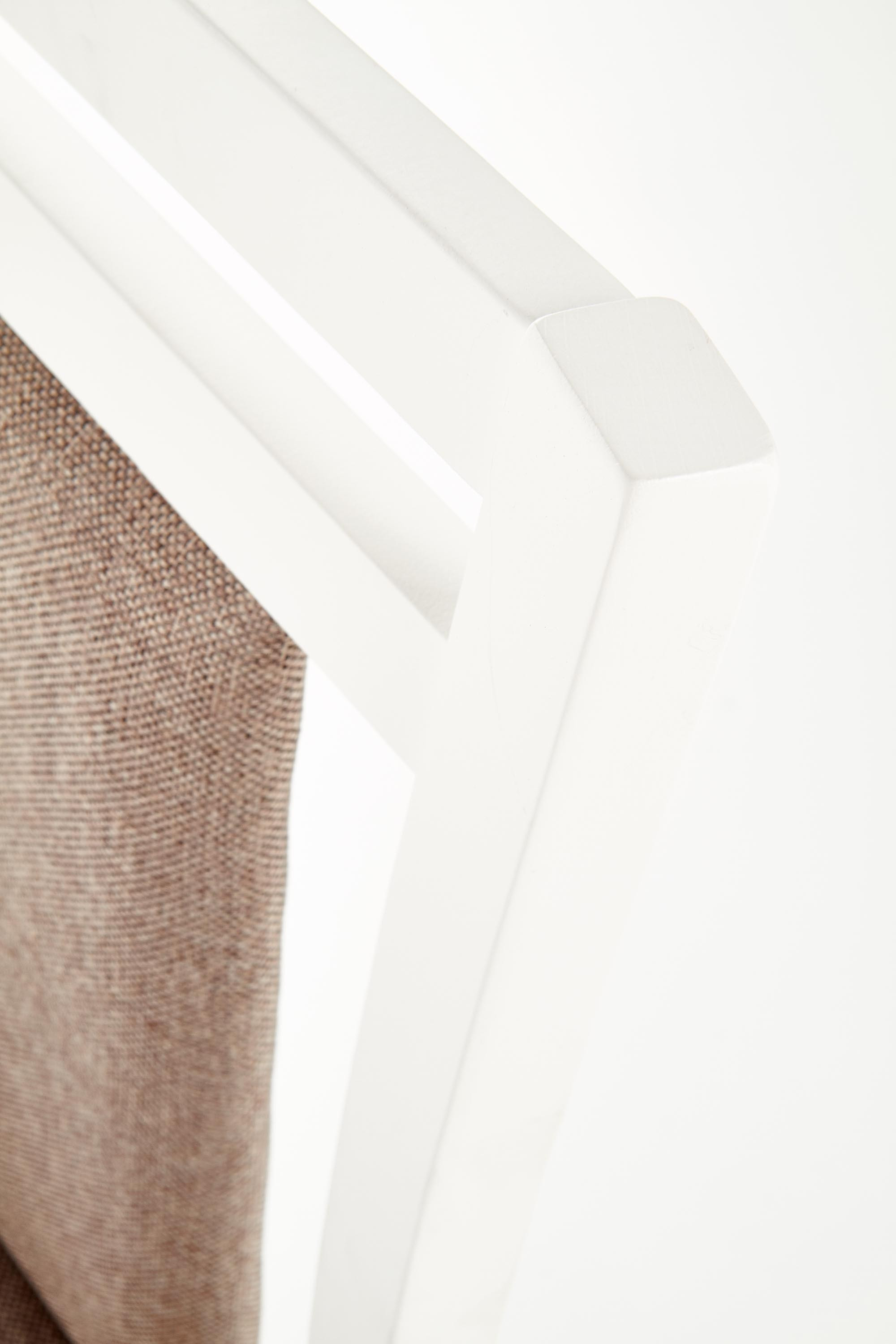 Zbliżenie na białą drewnianą ramę i tapicerowane oparcie krzesła HUBERT 8.