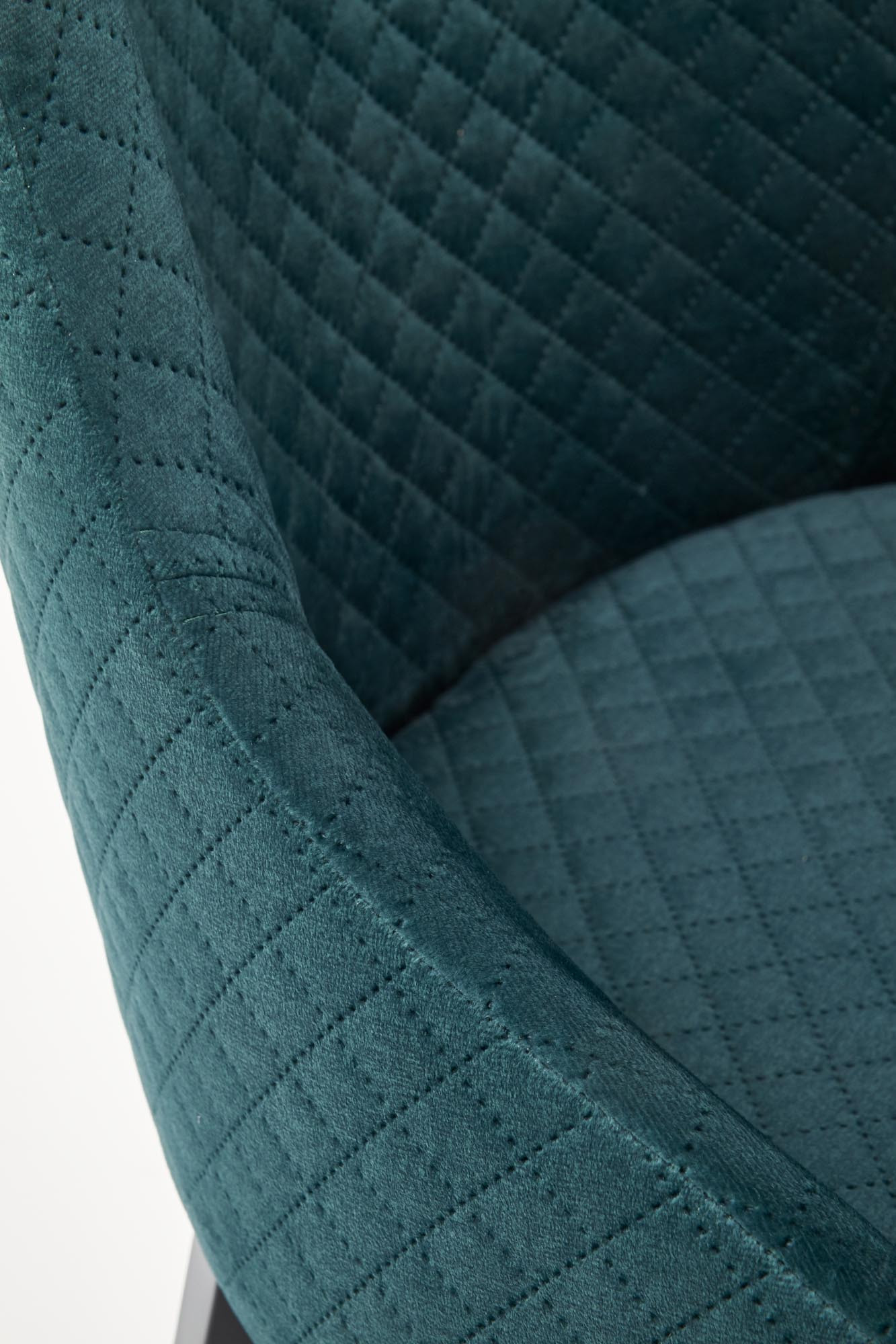 Zbliżenie na pikowane, zielone siedzisko i oparcie krzesła TOLEDO z czarnego drewna.