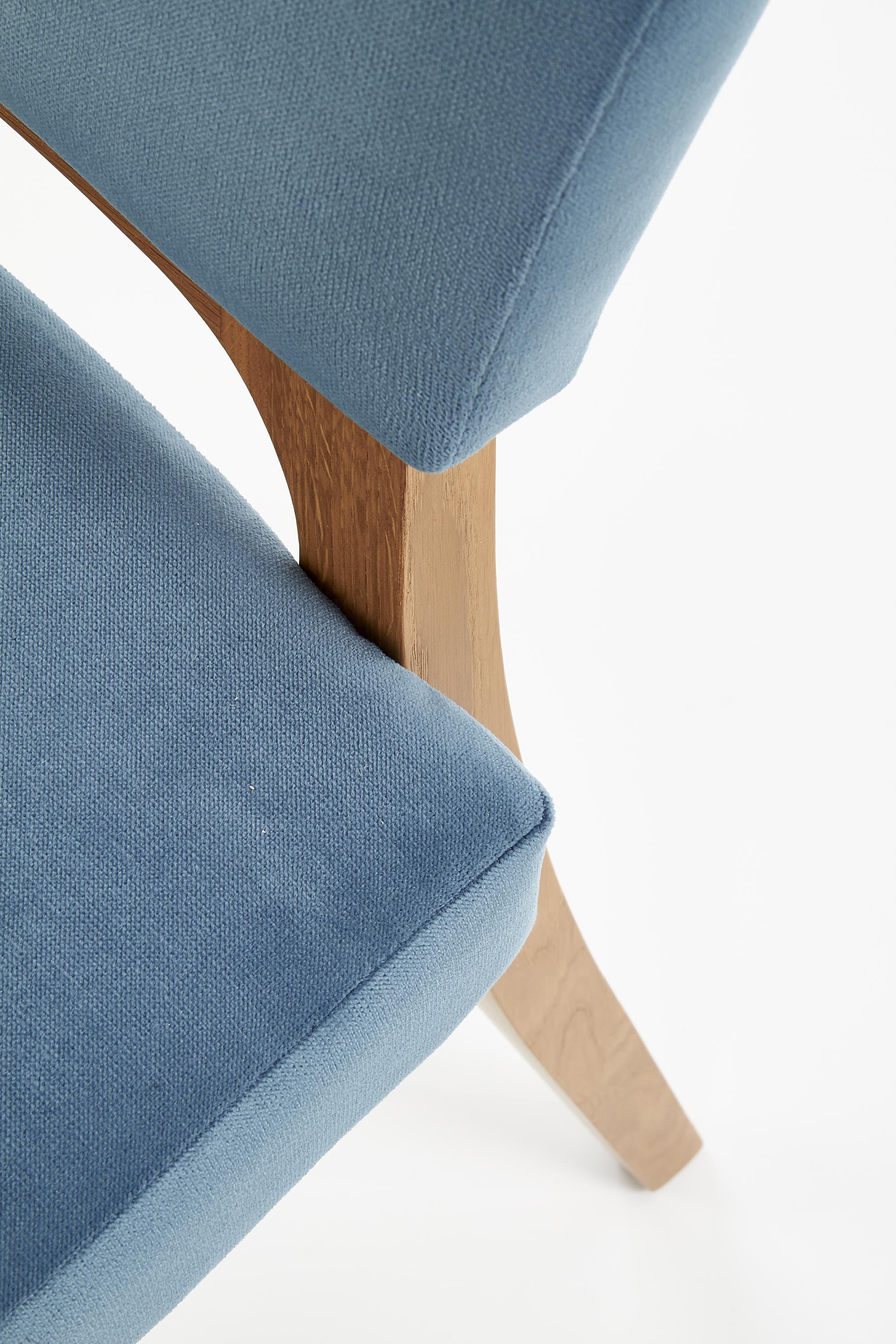 Zbliżenie na morskie siedzisko i oparcie krzesła WENANTY z miodowego dębu.