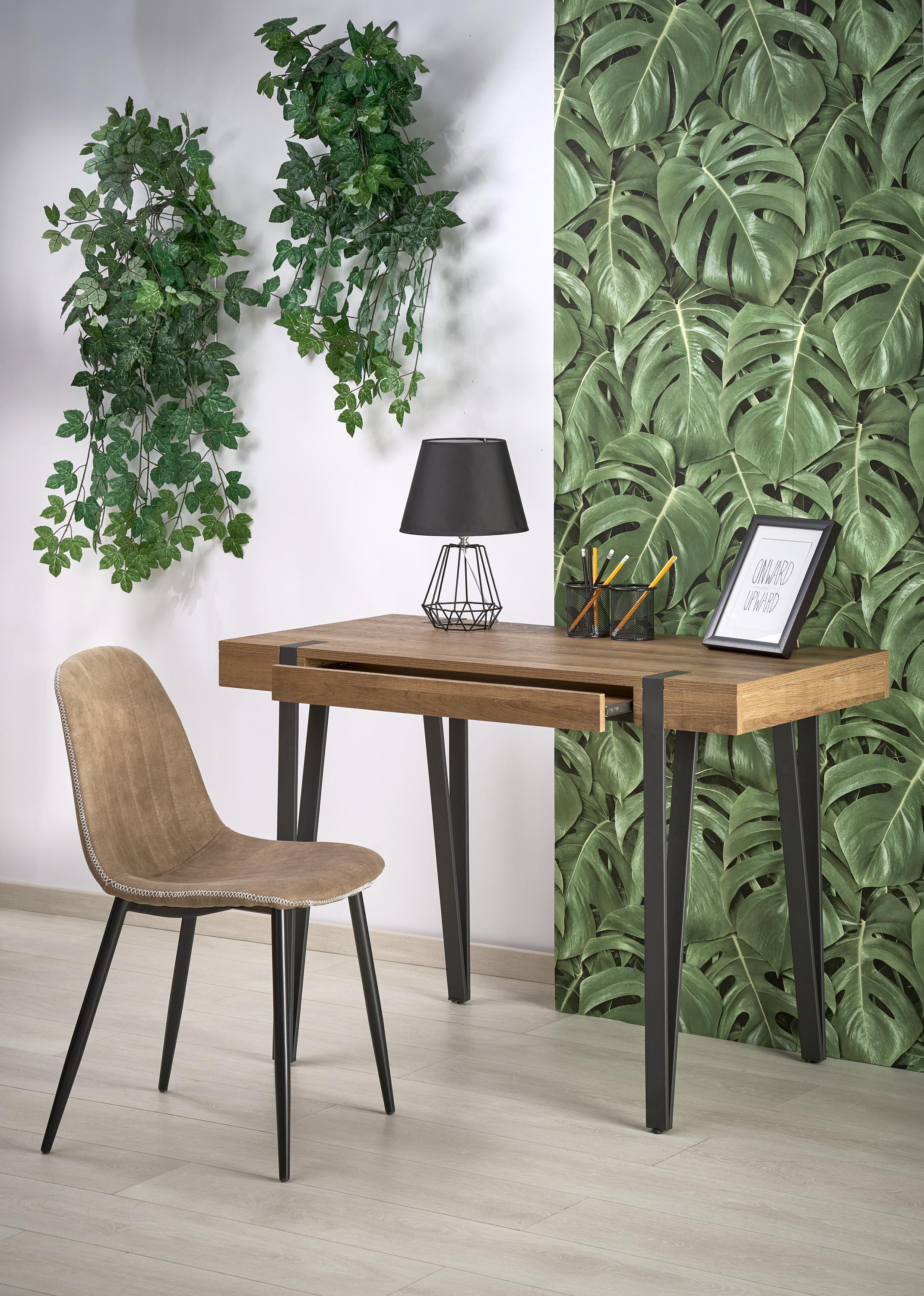 Biurko B39 z miodowego orzecha z czarnymi nogami – widok z przodu, krzesło beżowe, dekoracja roślinna na ścianie.