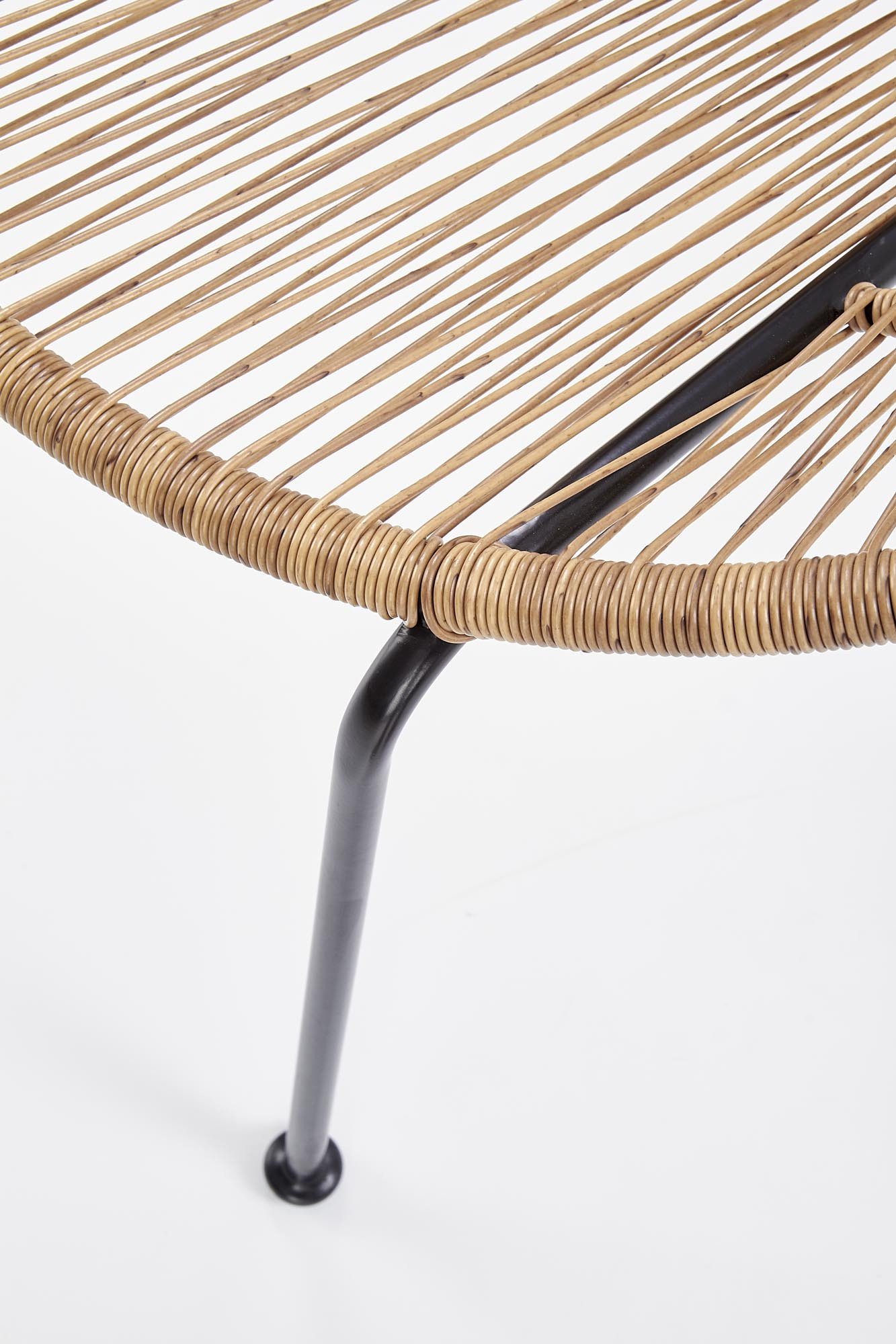 Zbliżenie na siedzisko fotela rattanowego BARI z naturalnego rattanu i czarnymi metalowymi nogami.