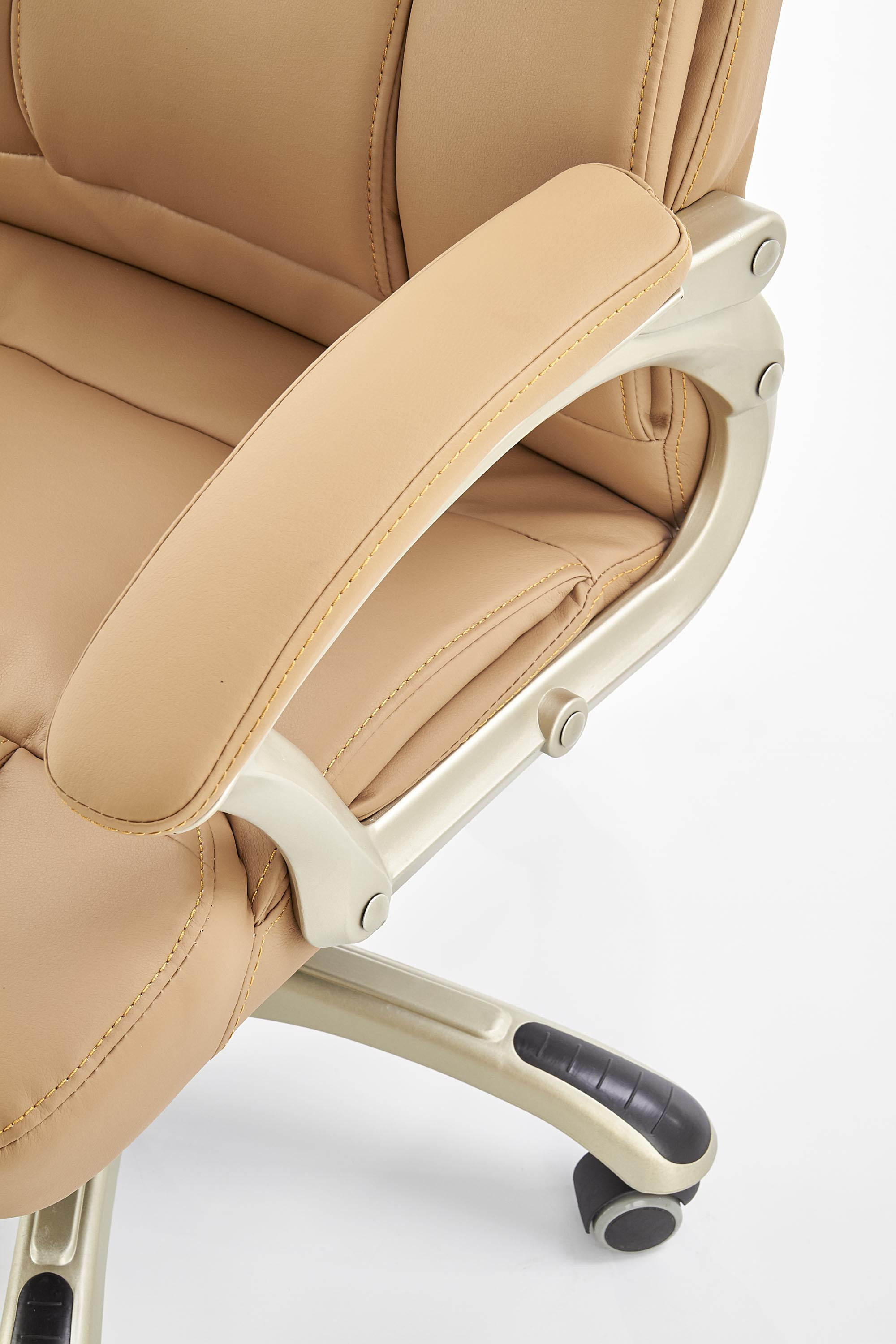 Zbliżenie na podłokietnik i siedzisko beżowego fotela gabinetowego DESMOND z eco skóry.