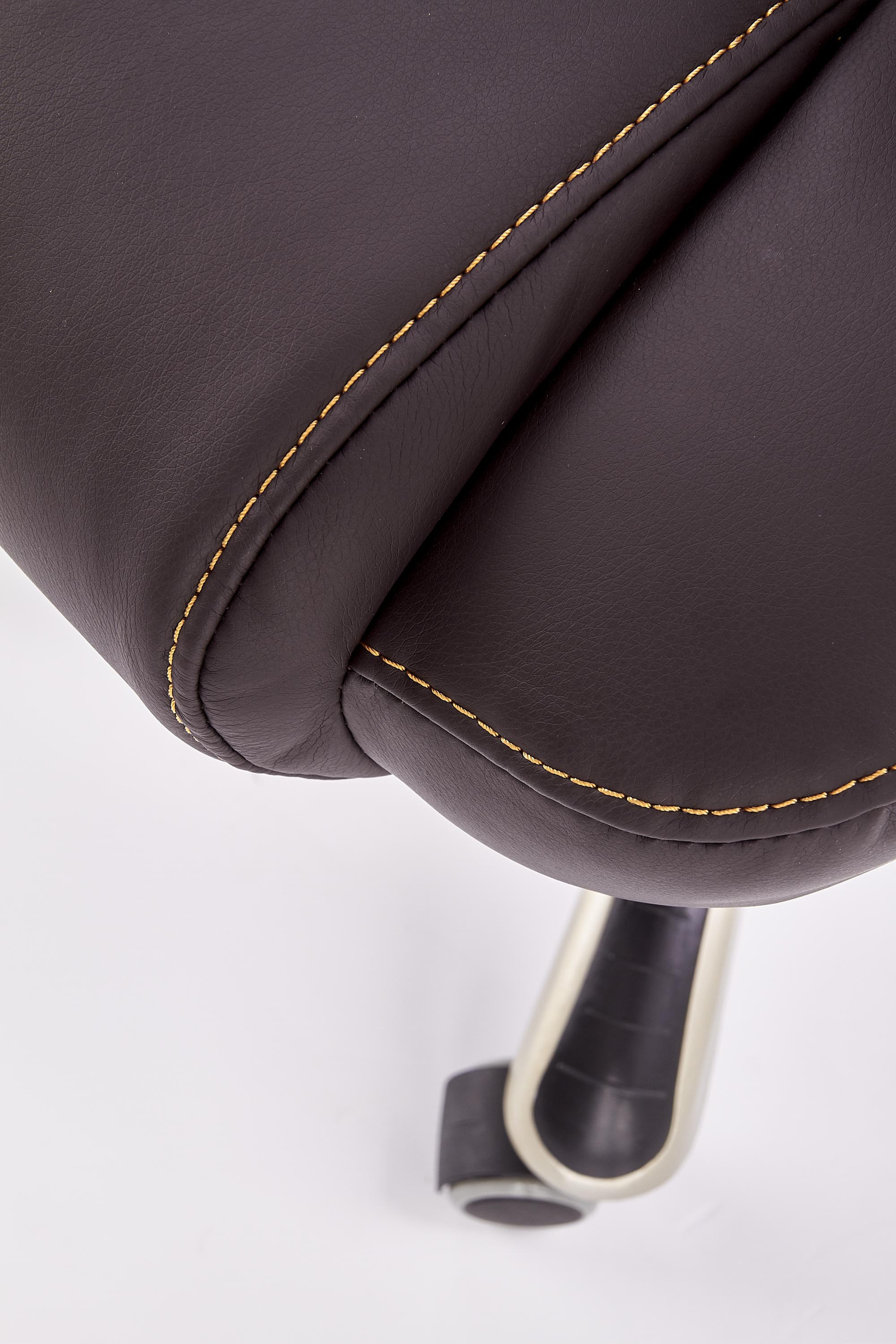 Zbliżenie na ciemnobrązową eco-skórę i szwy fotela gabinetowego DESMOND.