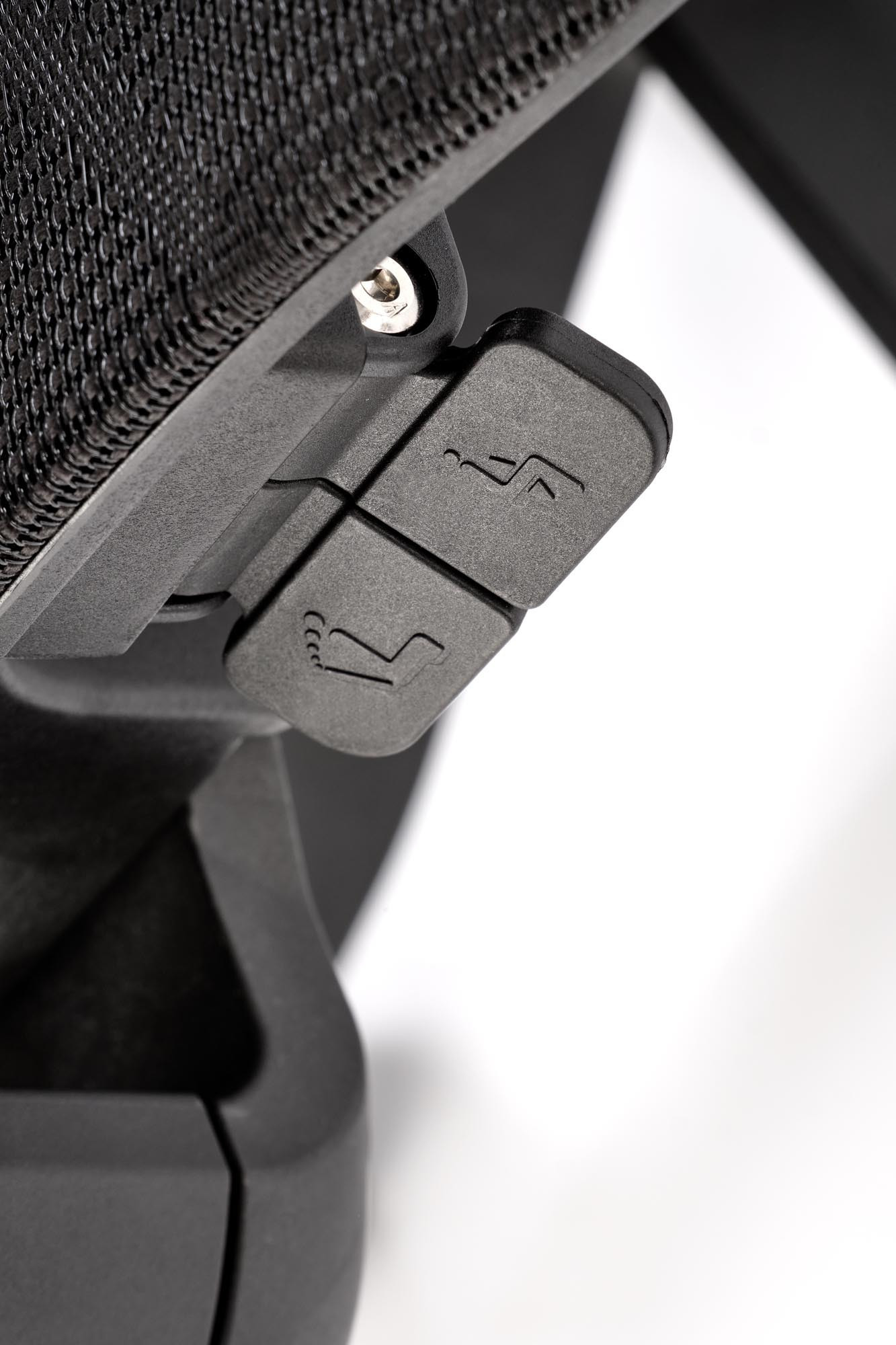 Zbliżenie na czarne przyciski regulacji fotela biurowego FREEMAN z siatkowym oparciem.