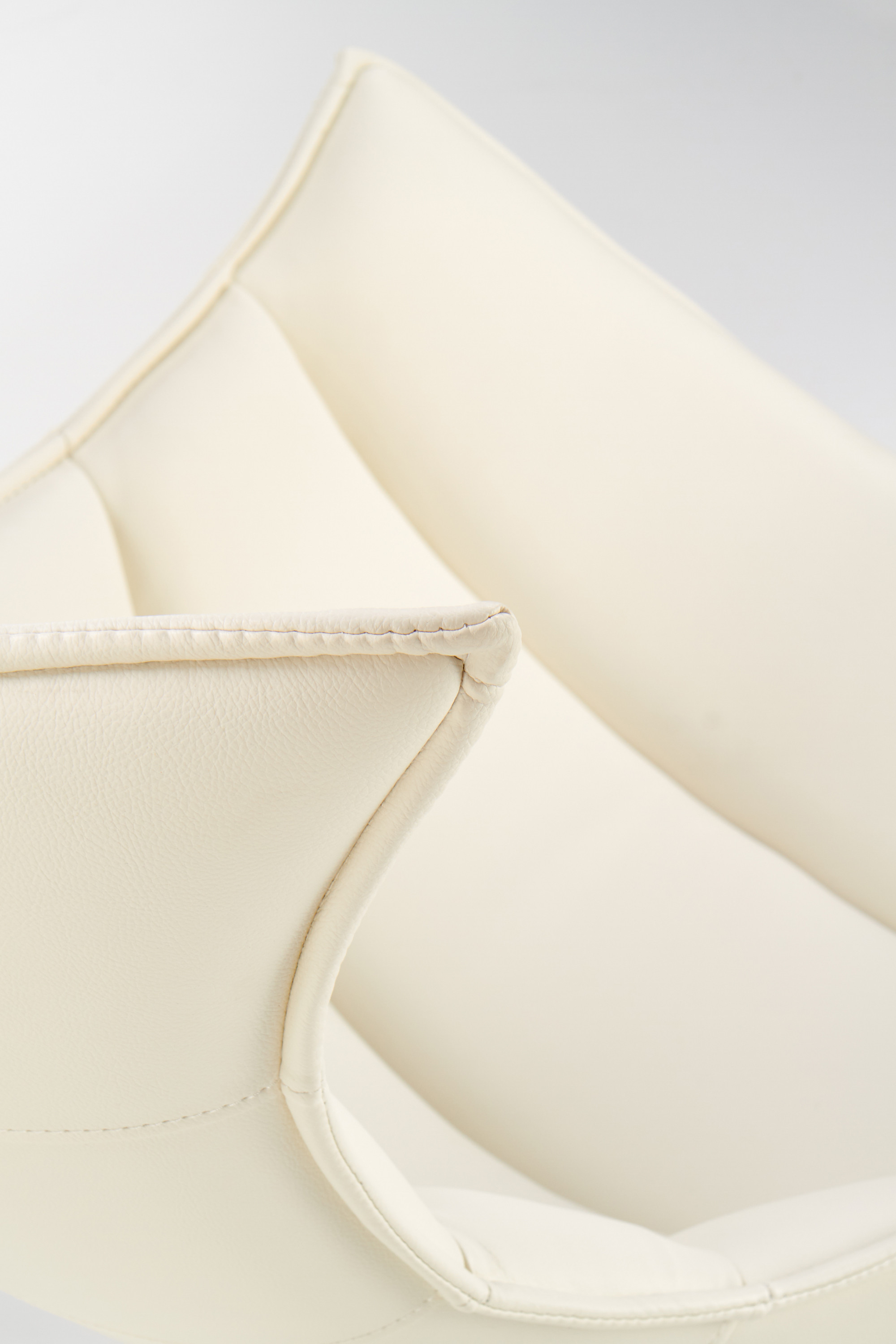 Zbliżenie na białą eco skórę fotela wypoczynkowego LUXOR z widocznymi przeszyciami.