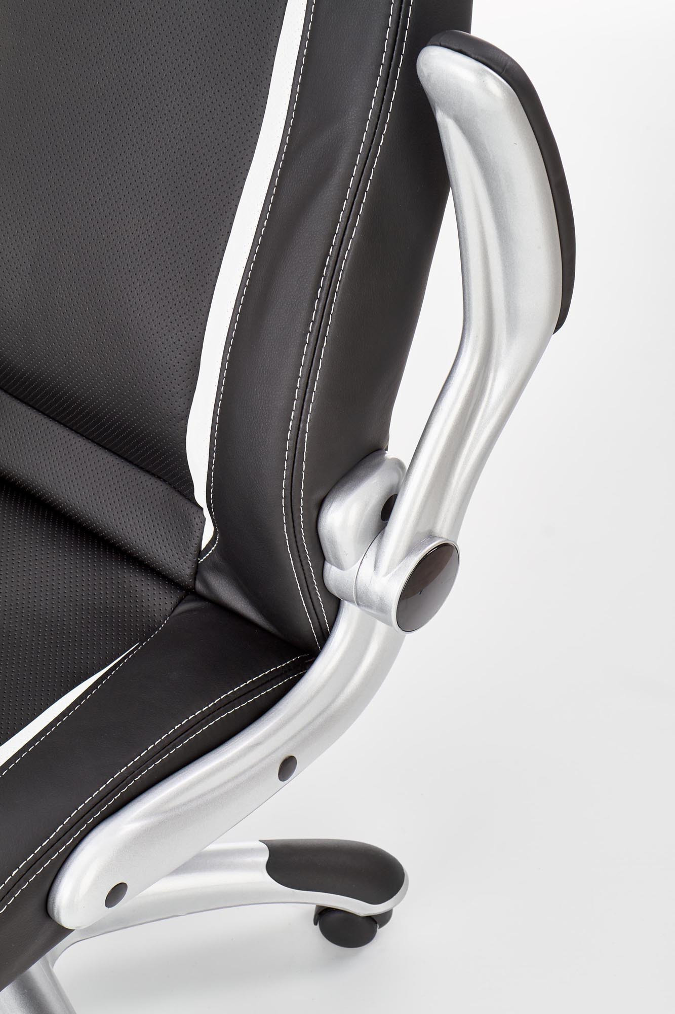 Zbliżenie na czarny fotel gabinetowy SATURN z eco skóry, srebrne podłokietniki i białe przeszycia.
