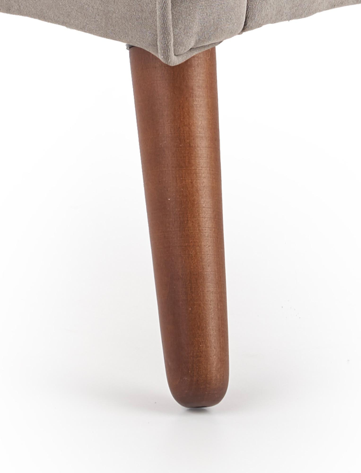 Detal drewnianej nóżki fotela FABIAN w kolorze orzecha.