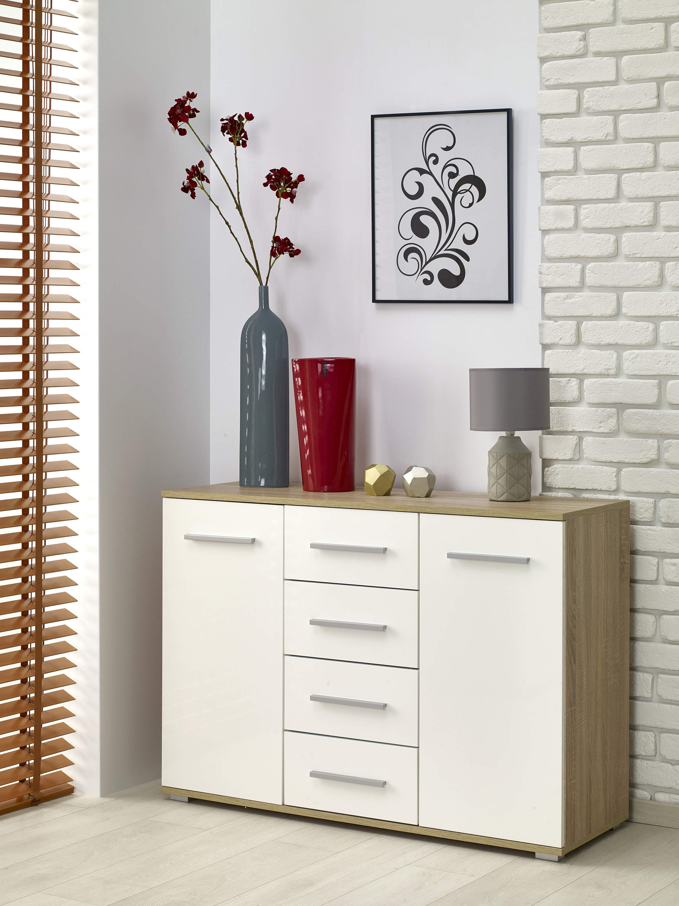 Widok z przodu nowoczesnej komody LIMA KM-4 w kolorze dąb biały, z czterema szufladami i dwoma szafkami.