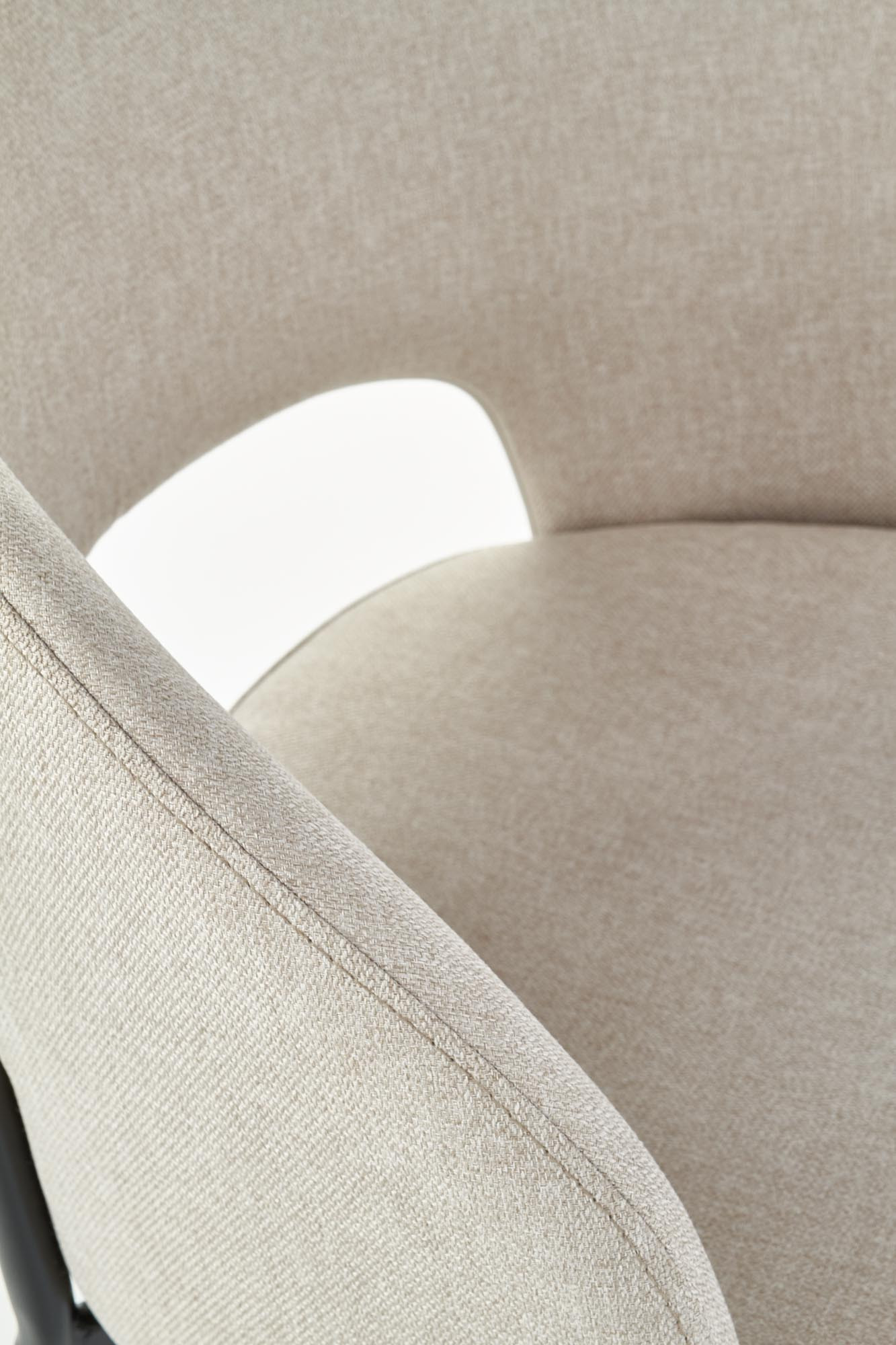 Zbliżenie na beżowe krzesło K373 z miękkim obiciem i zaokrąglonym oparciem.