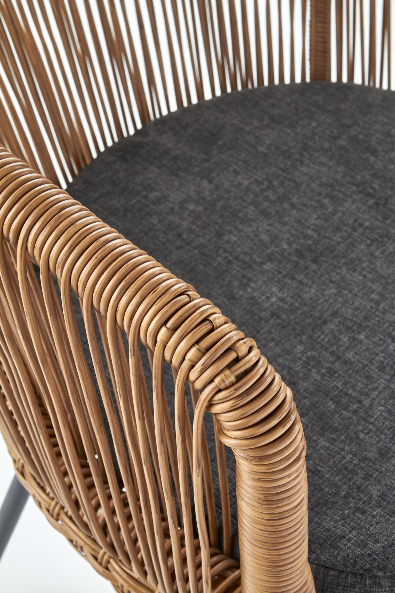 Zbliżenie na rattanowe oparcie i siedzisko krzesła K400 z szarą poduszką.