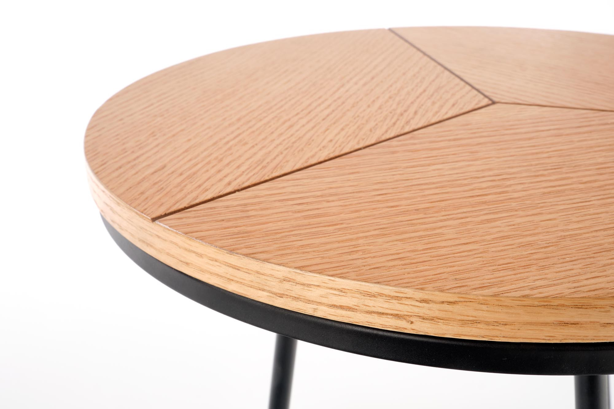 Zbliżenie na okrąły blat ławy KARIDA S z naturalnego dębu i czarnymi elementami.