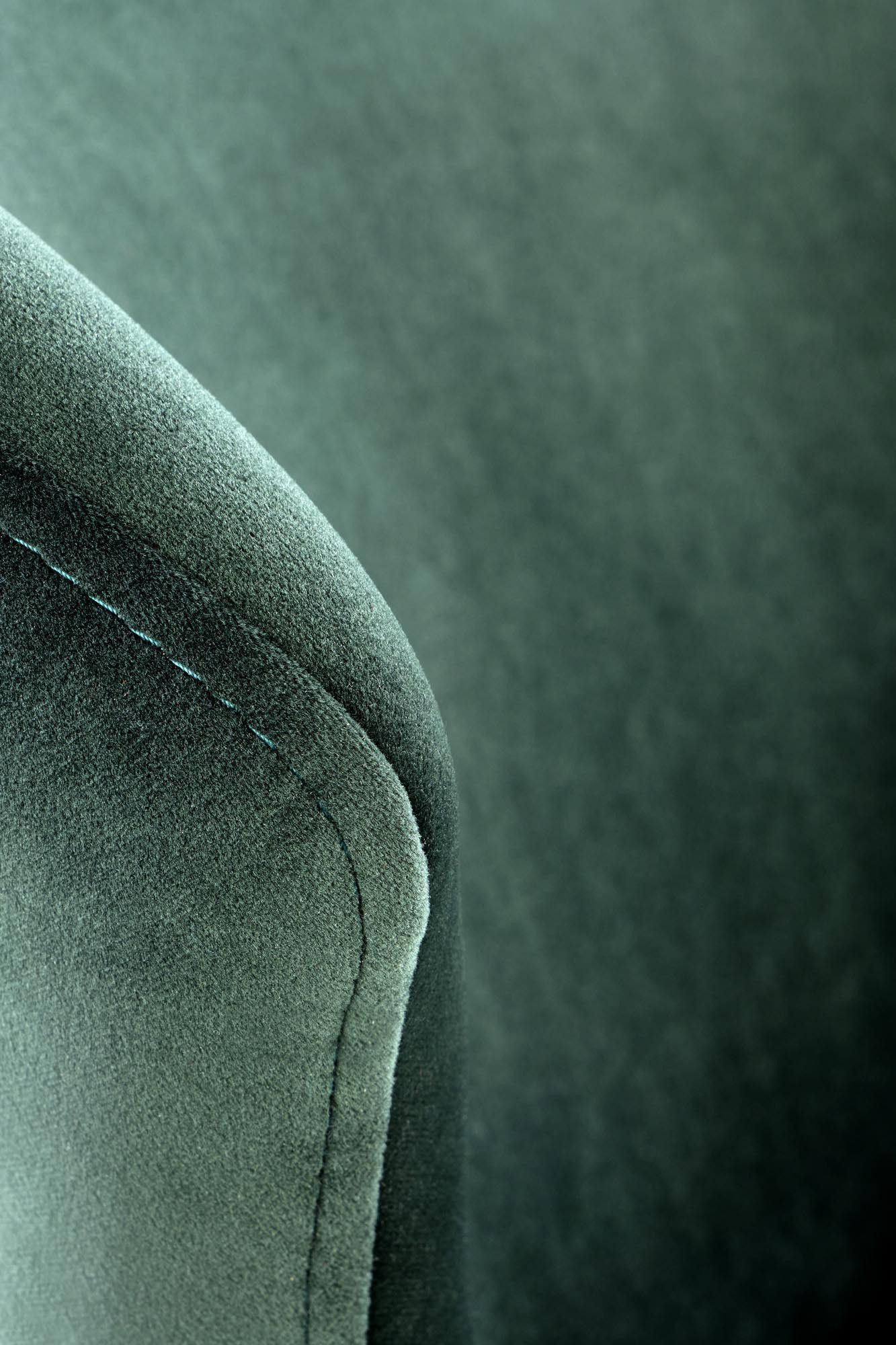 Zbliżenie na ciemnozielone obicie krzesła K458 Velvet z widocznym szwem.