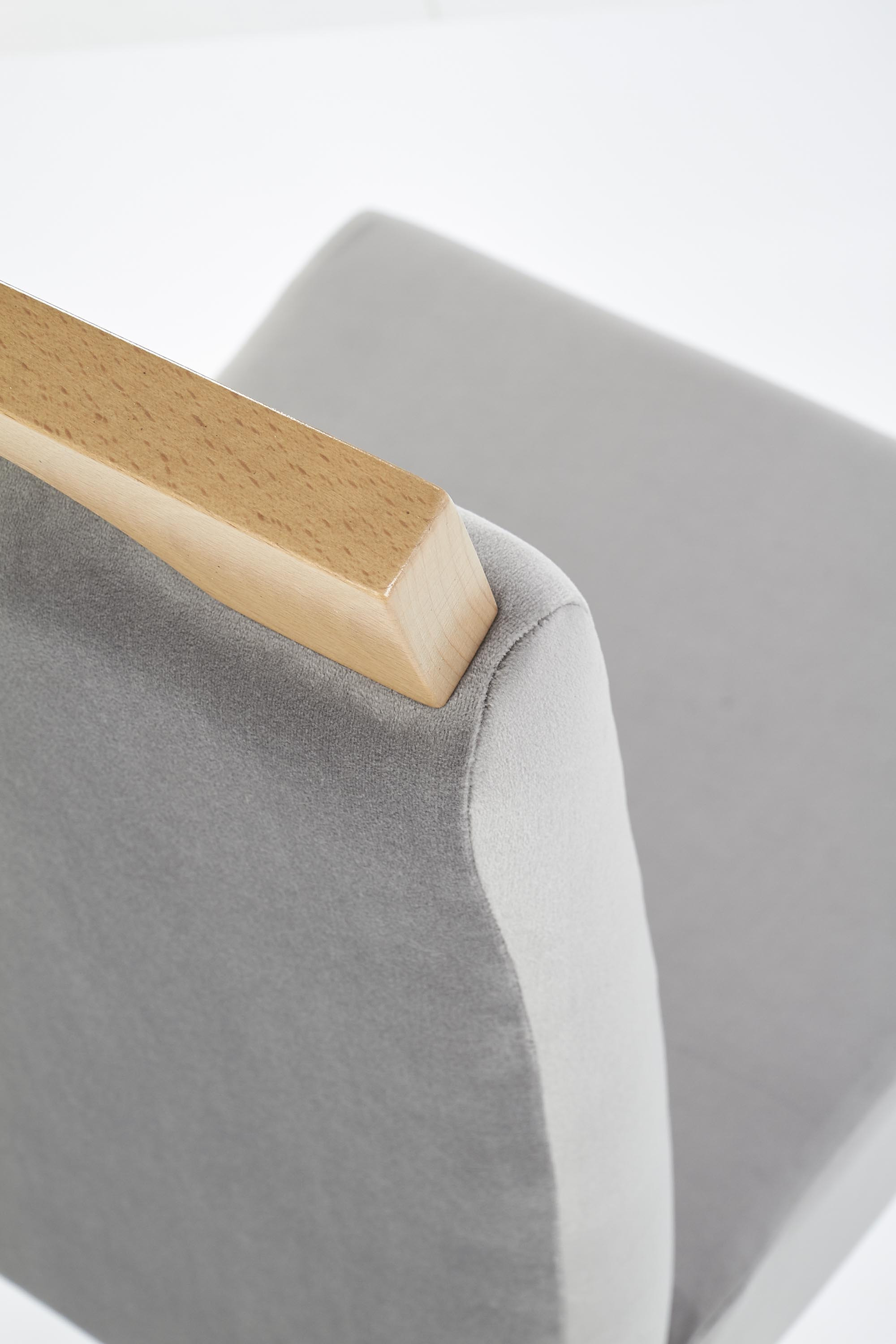 Widok z boku krzesła CLARION z miodowego dębu z szarą tapicerką.