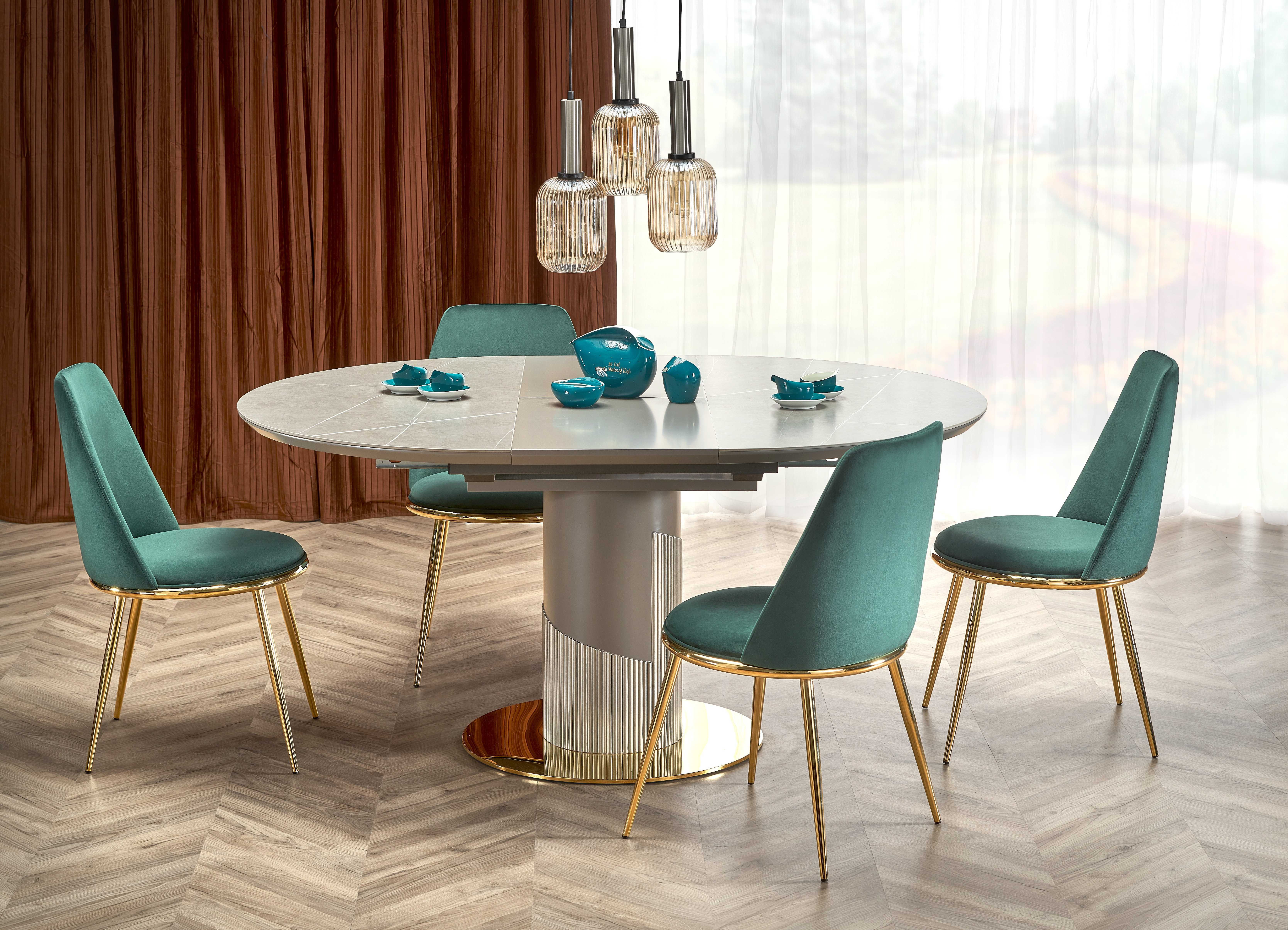 Popielaty stół owalny z marmurowym blatem i złotą podstawą, widok z góry.