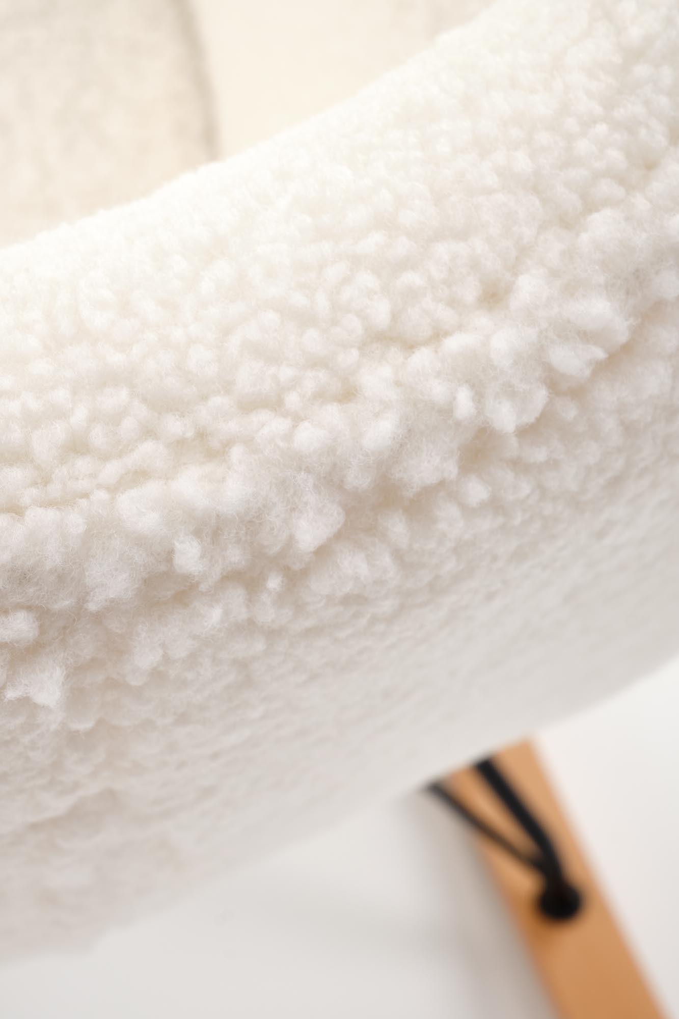 Zbliżenie na kremową tkaninę boucle fotela bujanego LIBERTO 2.