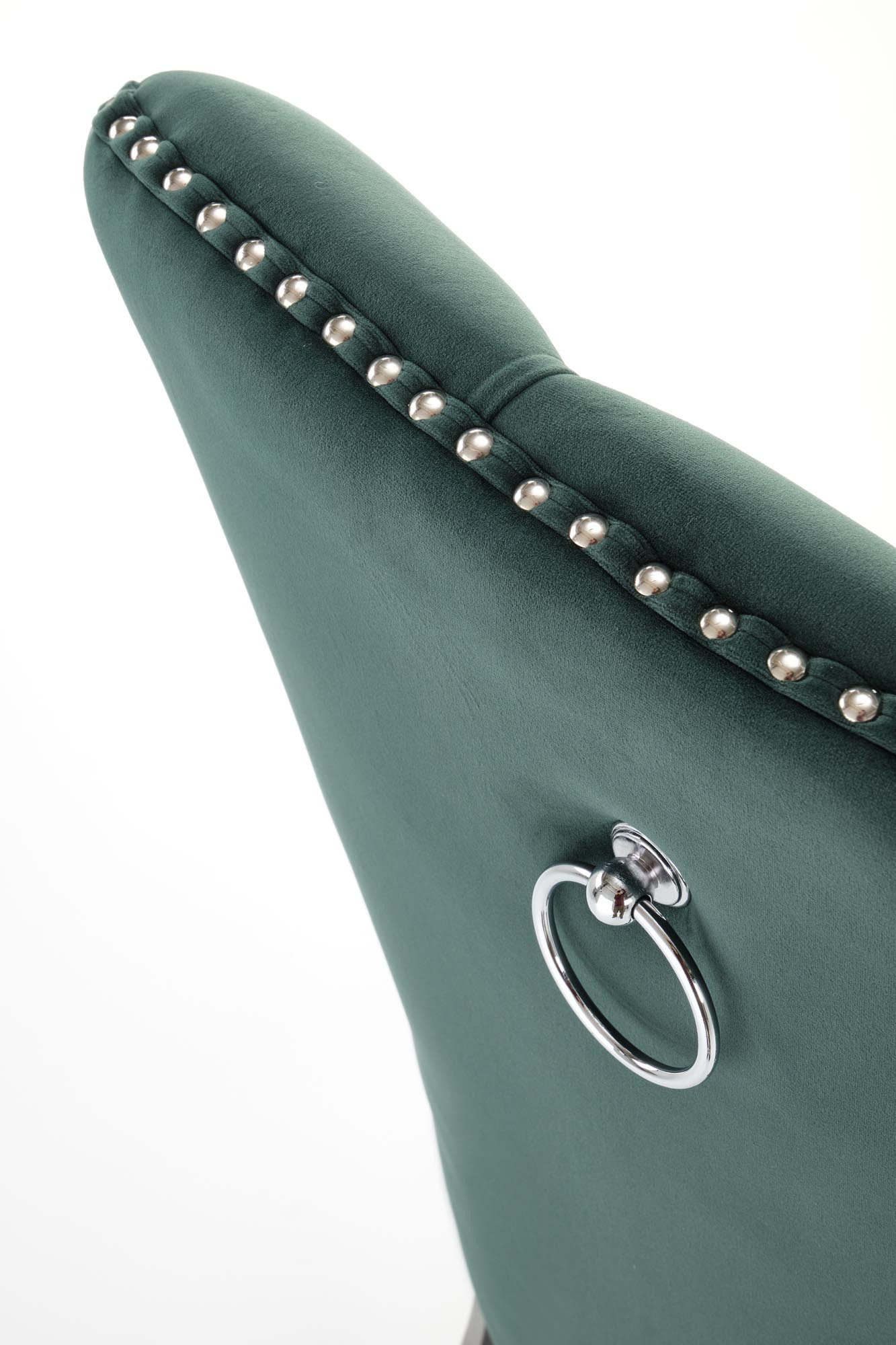 Zbliżenie na ciemnozielone oparcie krzesła MIYA z ozdobnymi ćwiekami i metalowym uchwytem.