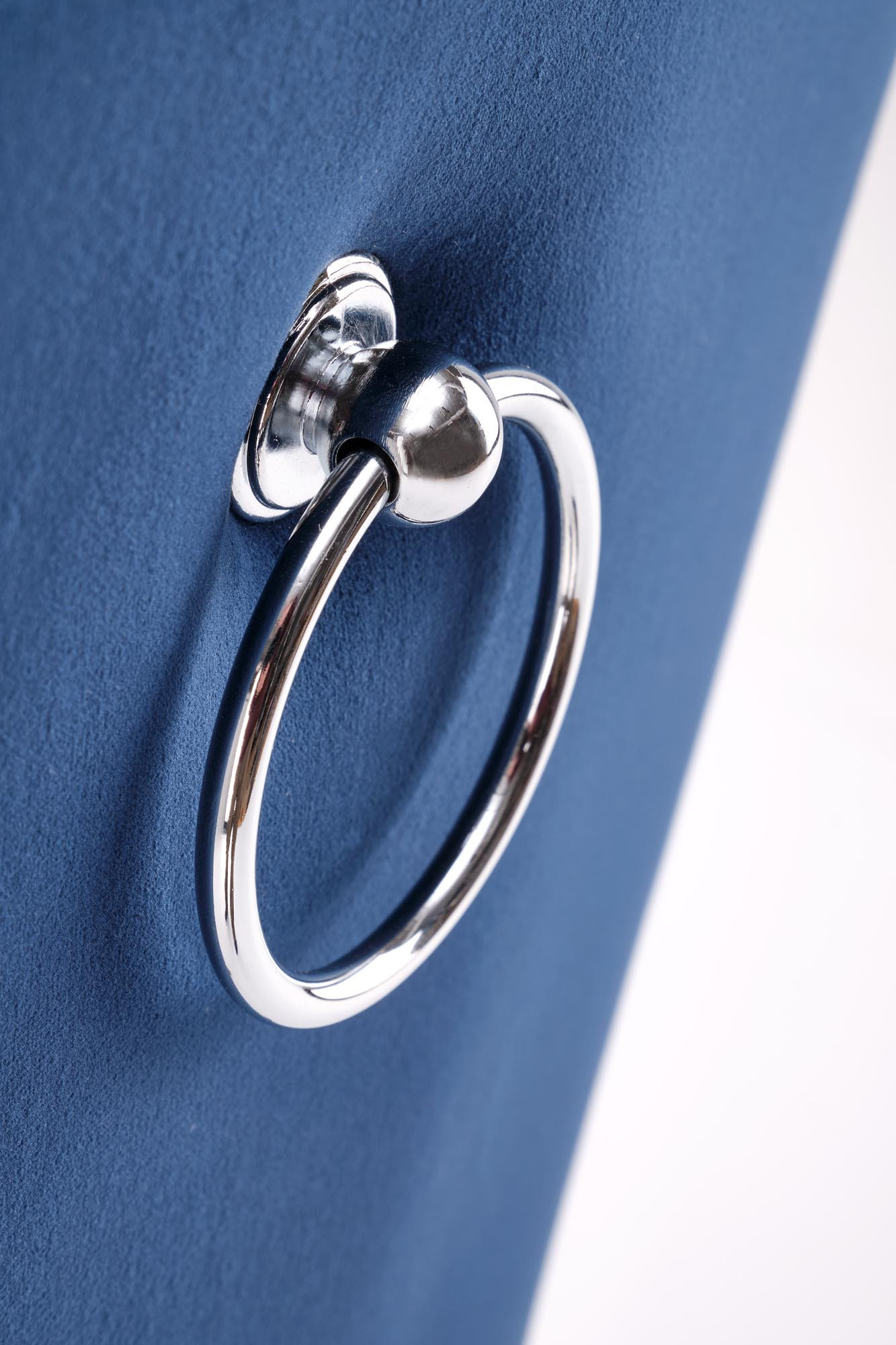 Zbliżenie na metalowy uchwyt na oparciu granatowego krzesła velvet MIYA.