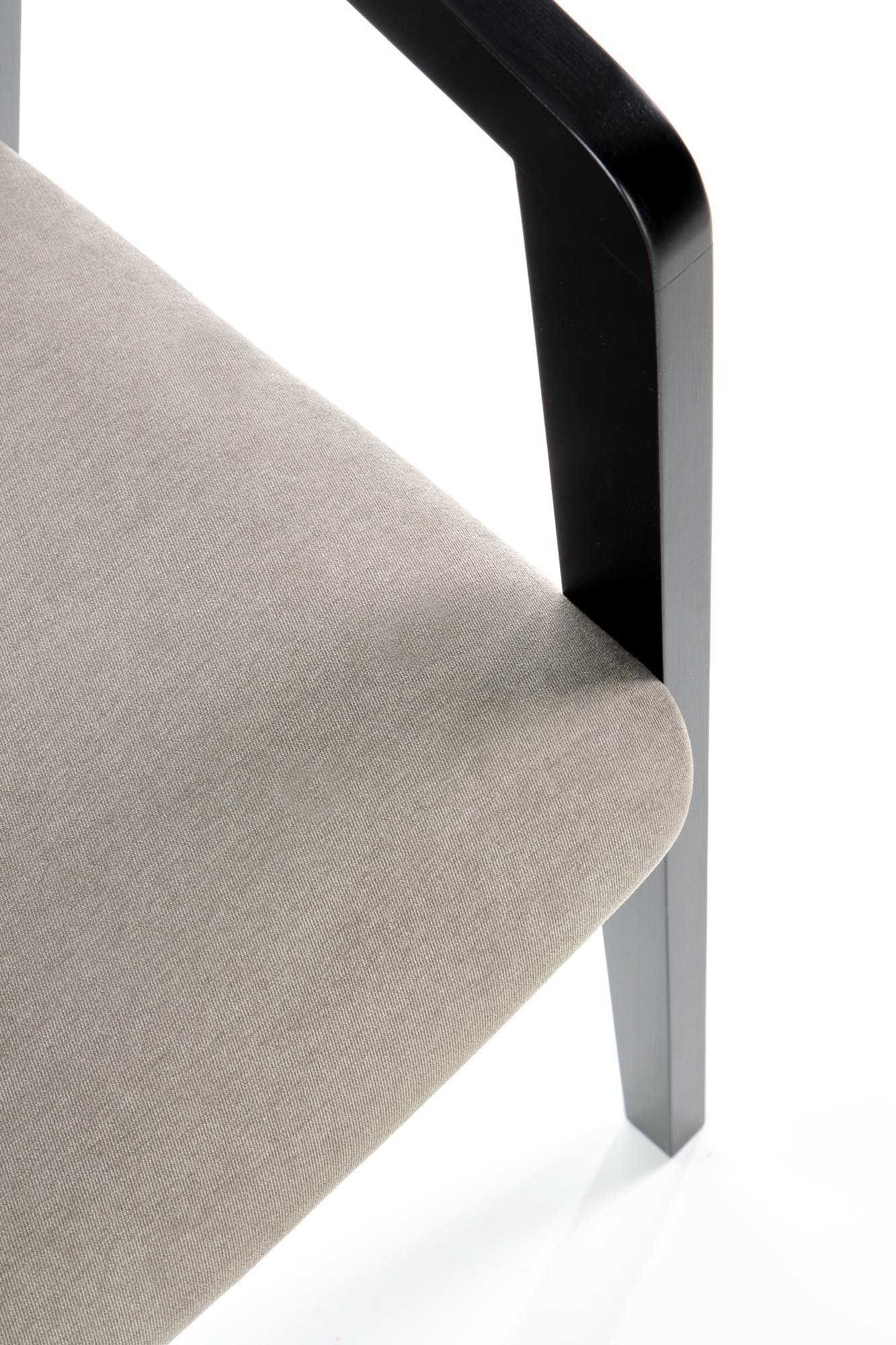 Zbliżenie na popielate welurowe siedzisko krzesła AZUL z czarnymi drewnianymi nogami.