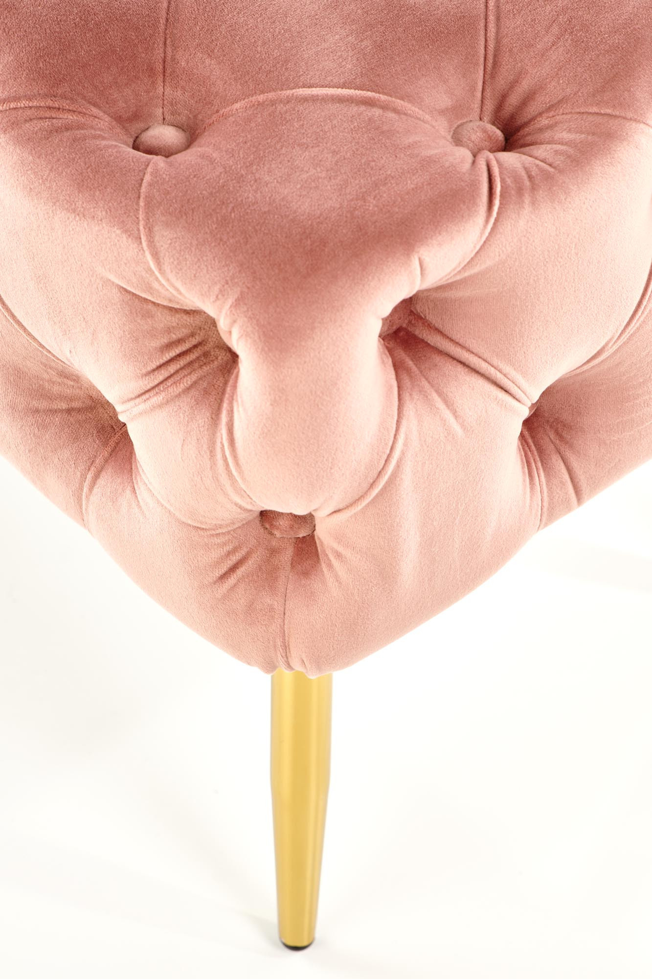 Zbliżenie na różowe, aksamitne pikowane siedzisko ławki ATHENA z złotą nogą.