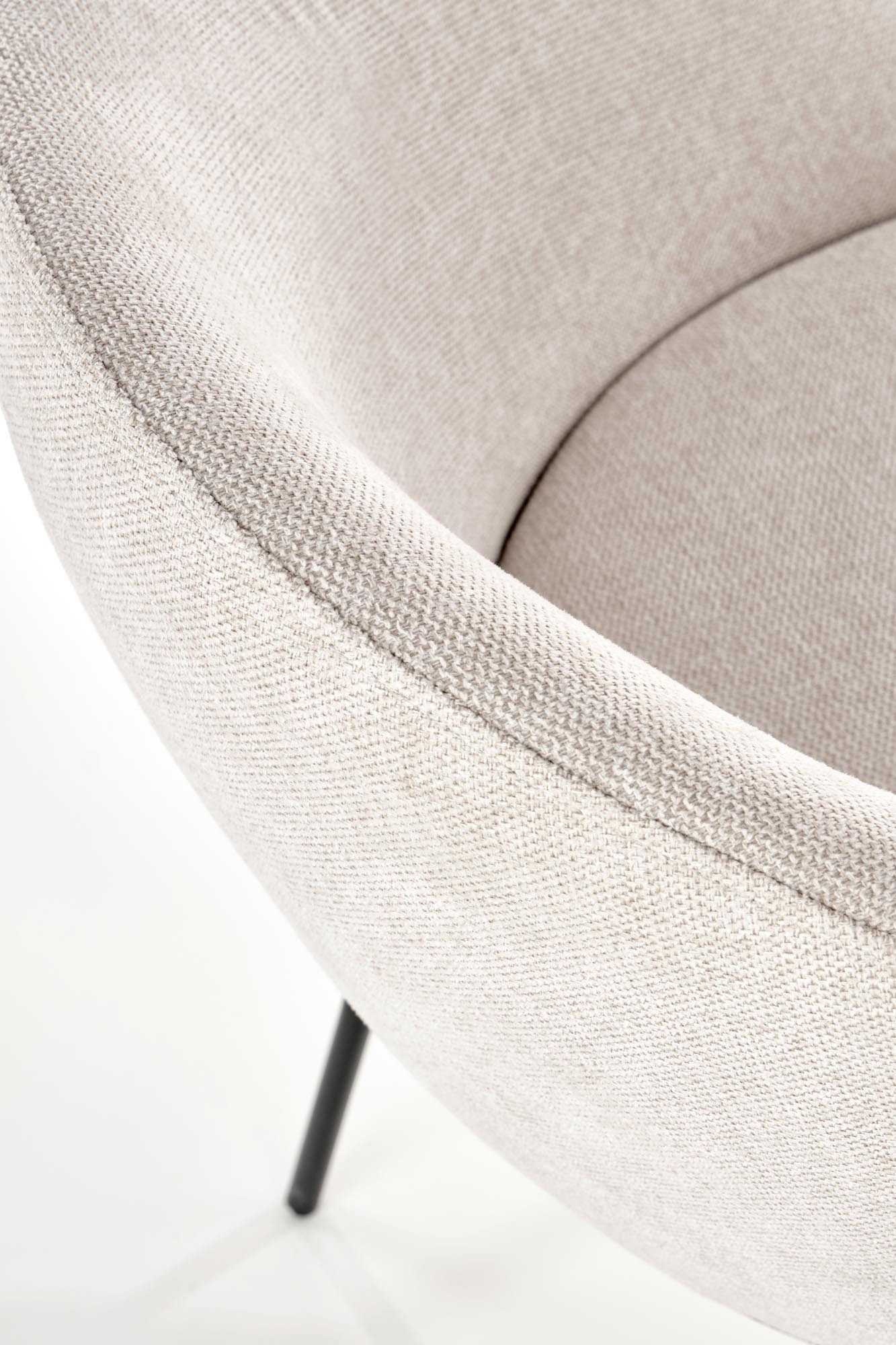 Zbliżenie na beżową tapicerkę i czarne nogi krzesła K482.