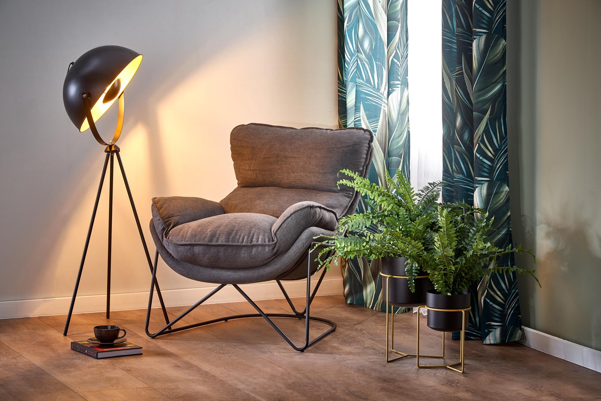 Zbliżenie na ciemnopopielaty fotel NERVAL z metalowymi nogami i miękkim obiciem.