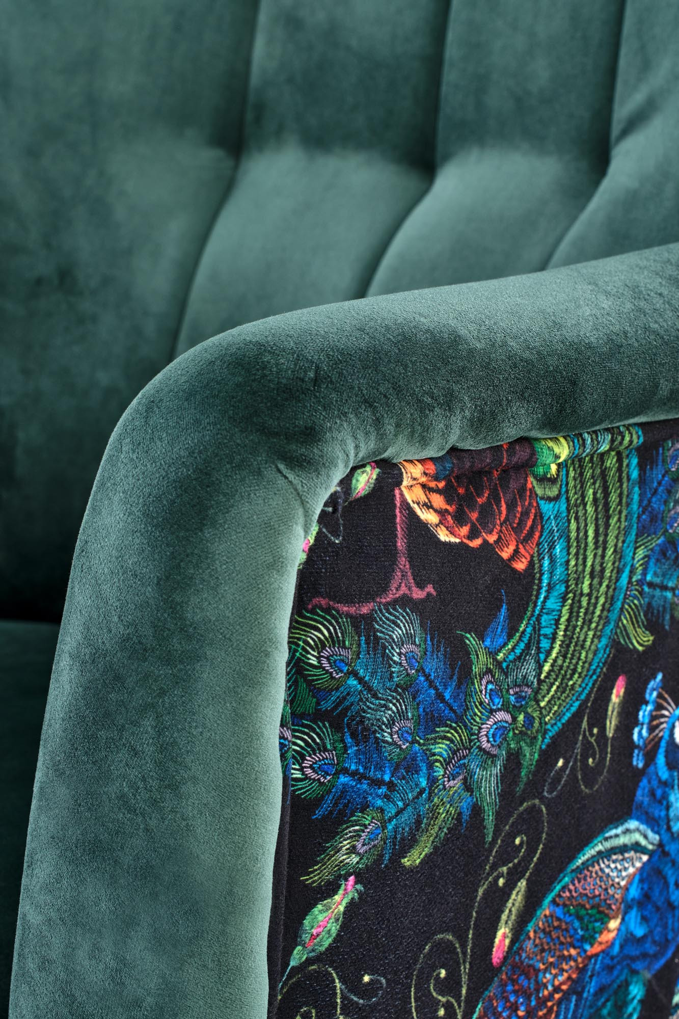 Zbliżenie na boczne wzorzyste obicie zielonego fotela PAGONI z aksamitnym wykończeniem.