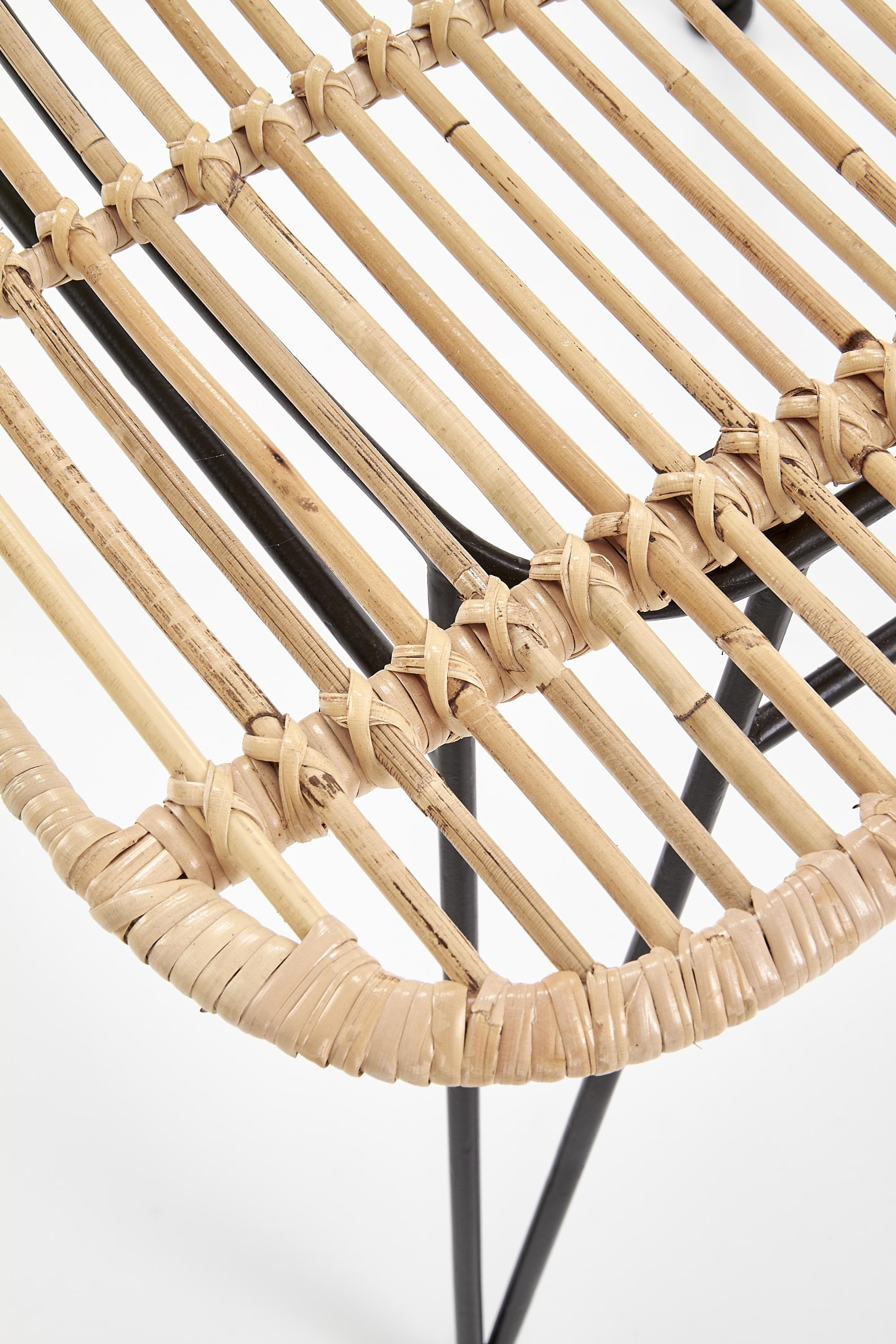 Widok z przodu krzesła K337 z naturalnego rattanu i czarnymi metalowymi nogami.