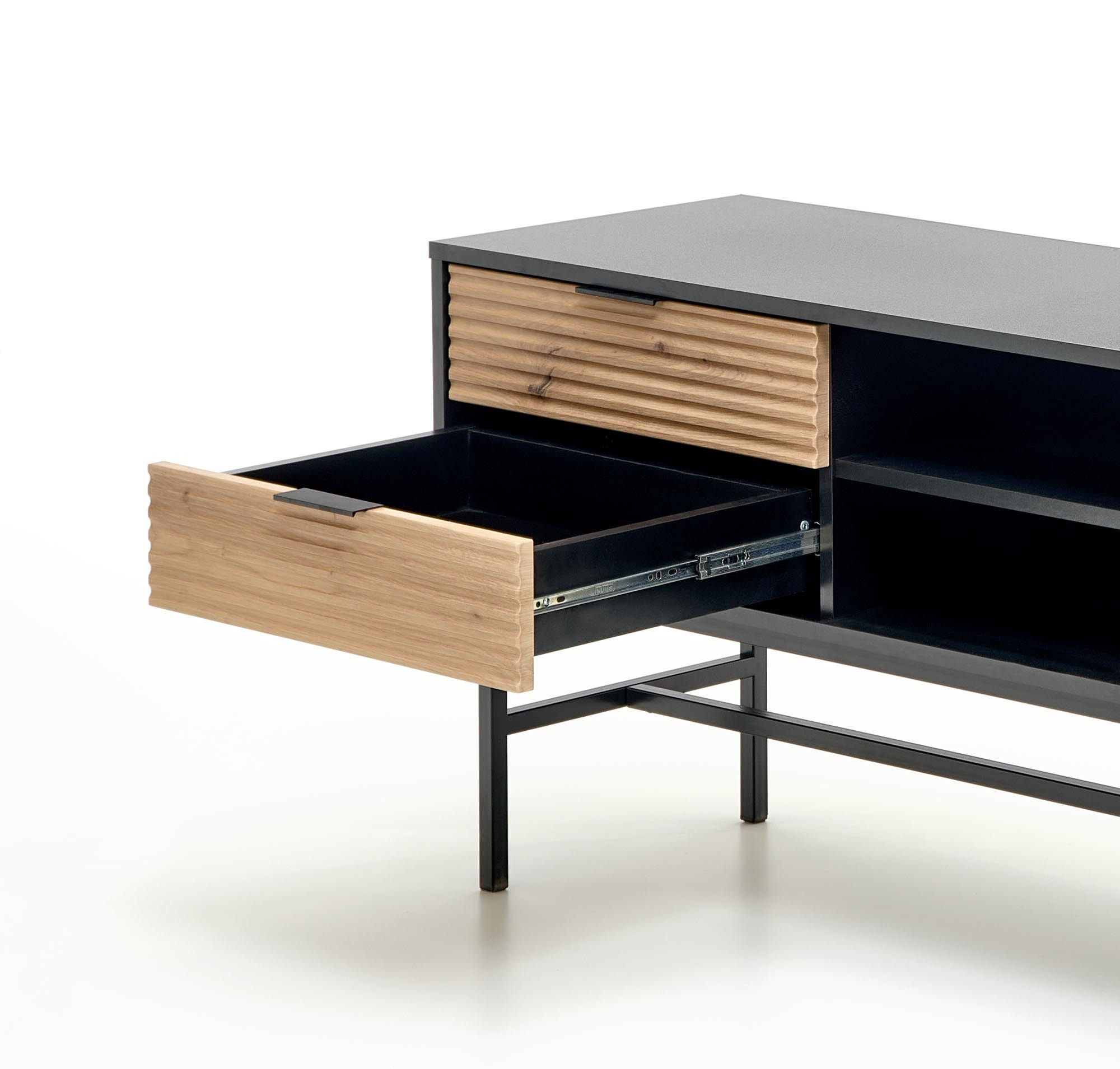 Zbliżenie na otwartą szufladę stolika RTV MURANO z dębu artisan i czarnego metalu.