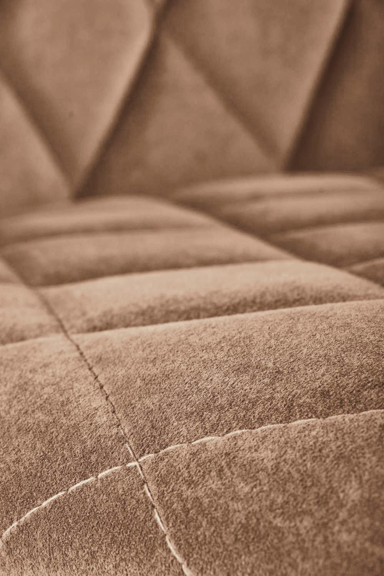 Zbliżenie na pikowane beżowe siedzisko krzesła K450 Bluvel 28 z nowoczesnym designem.