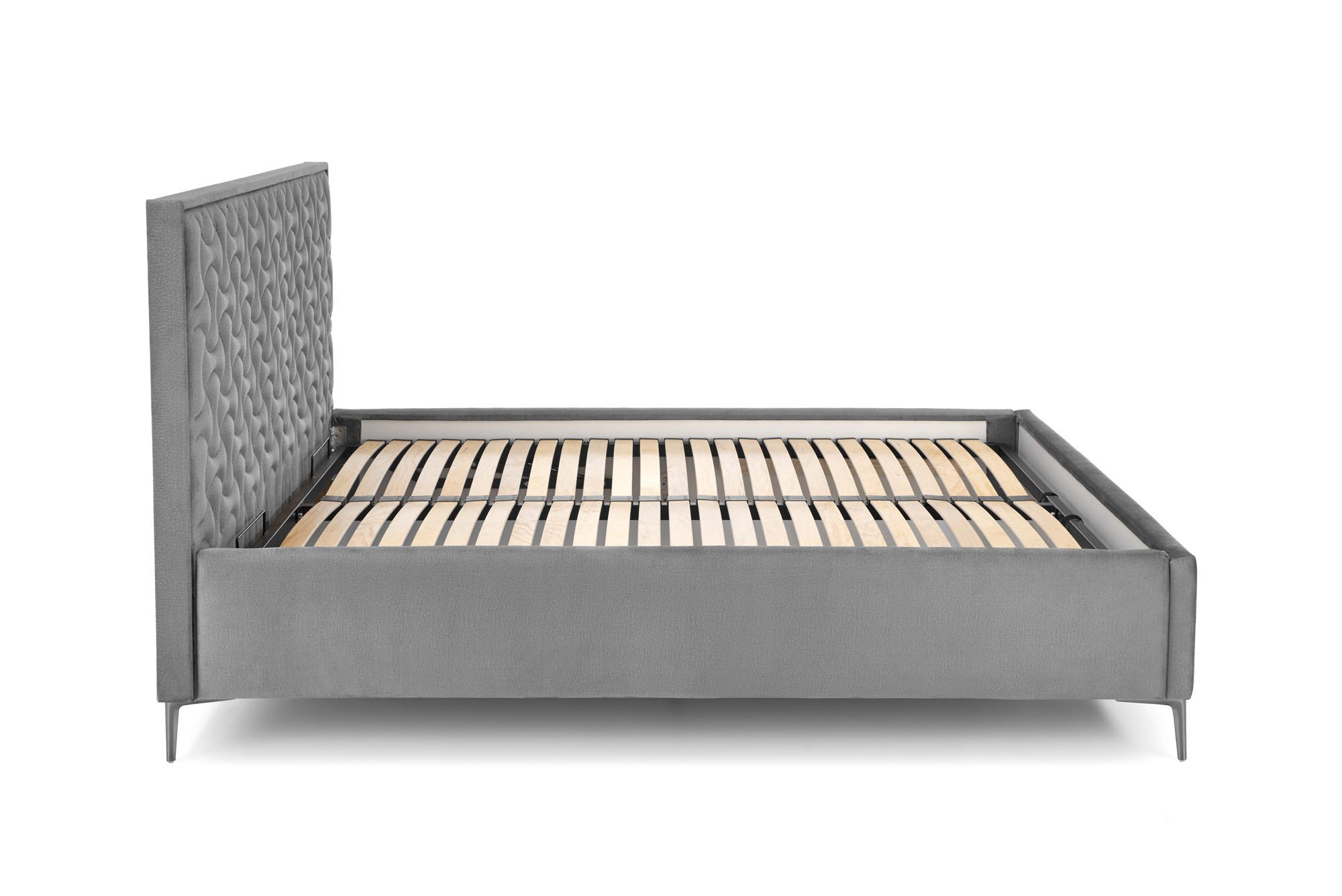 Boczny widok łóżka Sereno z popielatym welwetowym wezgłowiem i nowoczesnym wzorem.