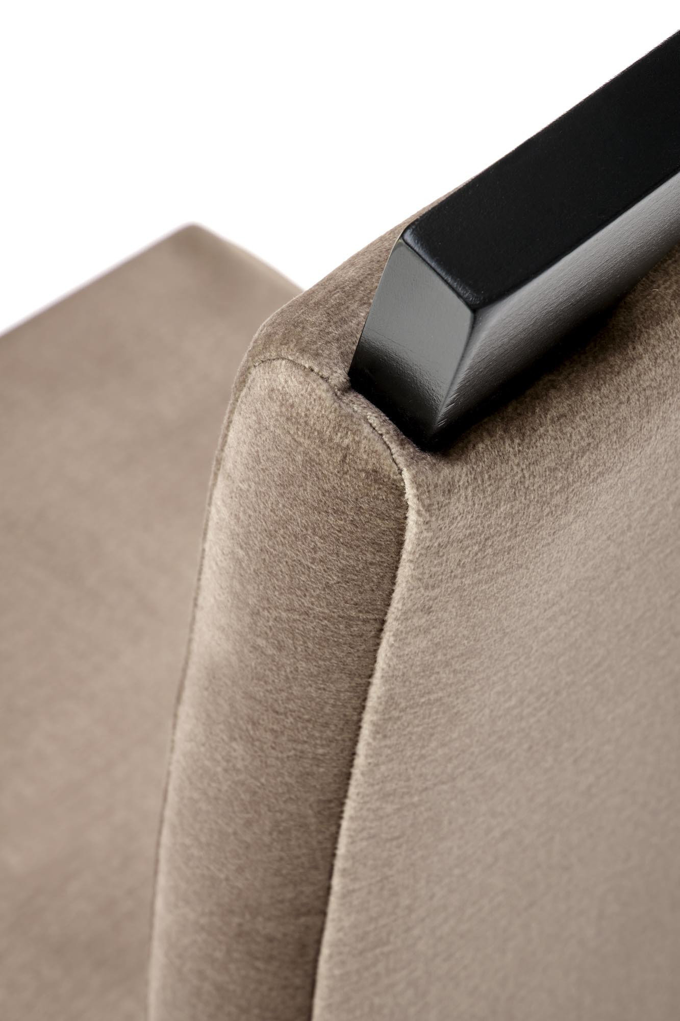 Zbliżenie na czarne podłokietniki i beżową tapicerkę krzesła HERMAN2 Monolith 09.