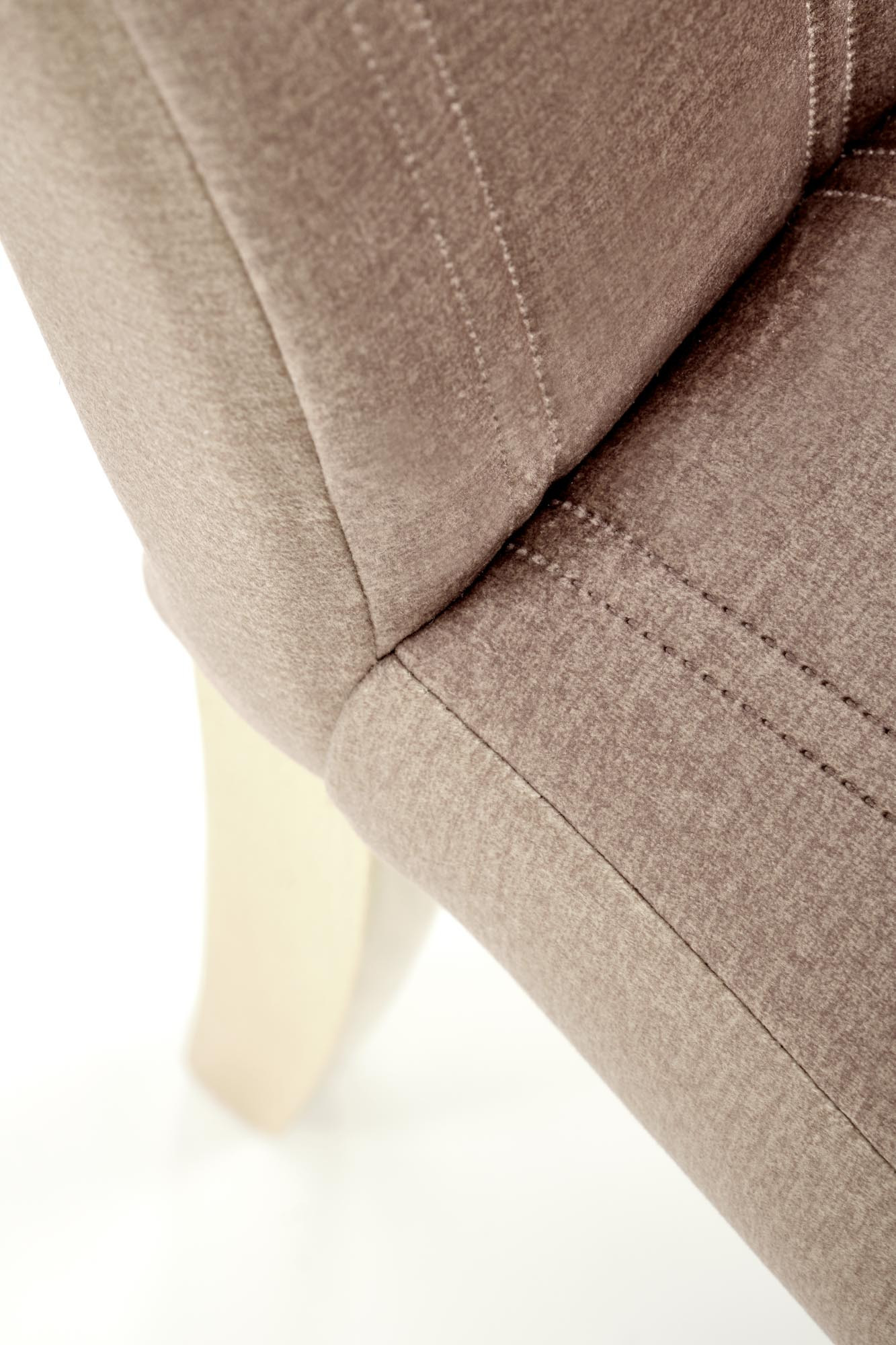 Zbliżenie na beżowy welur z pikowanymi pasami krzesła MERMI3.