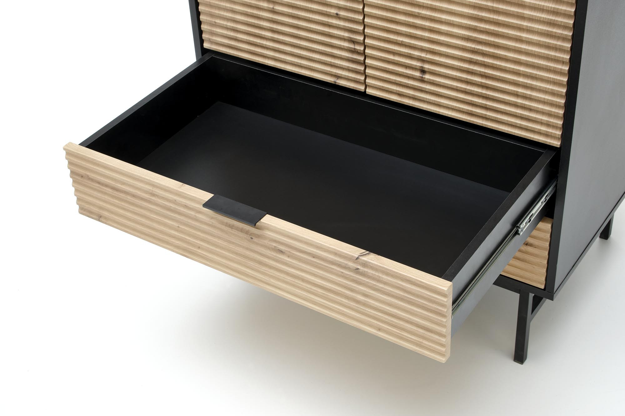 Zbliżenie na otwartą szufladę szafy MURANO z dębu artisan z czarnym wnętrzem.