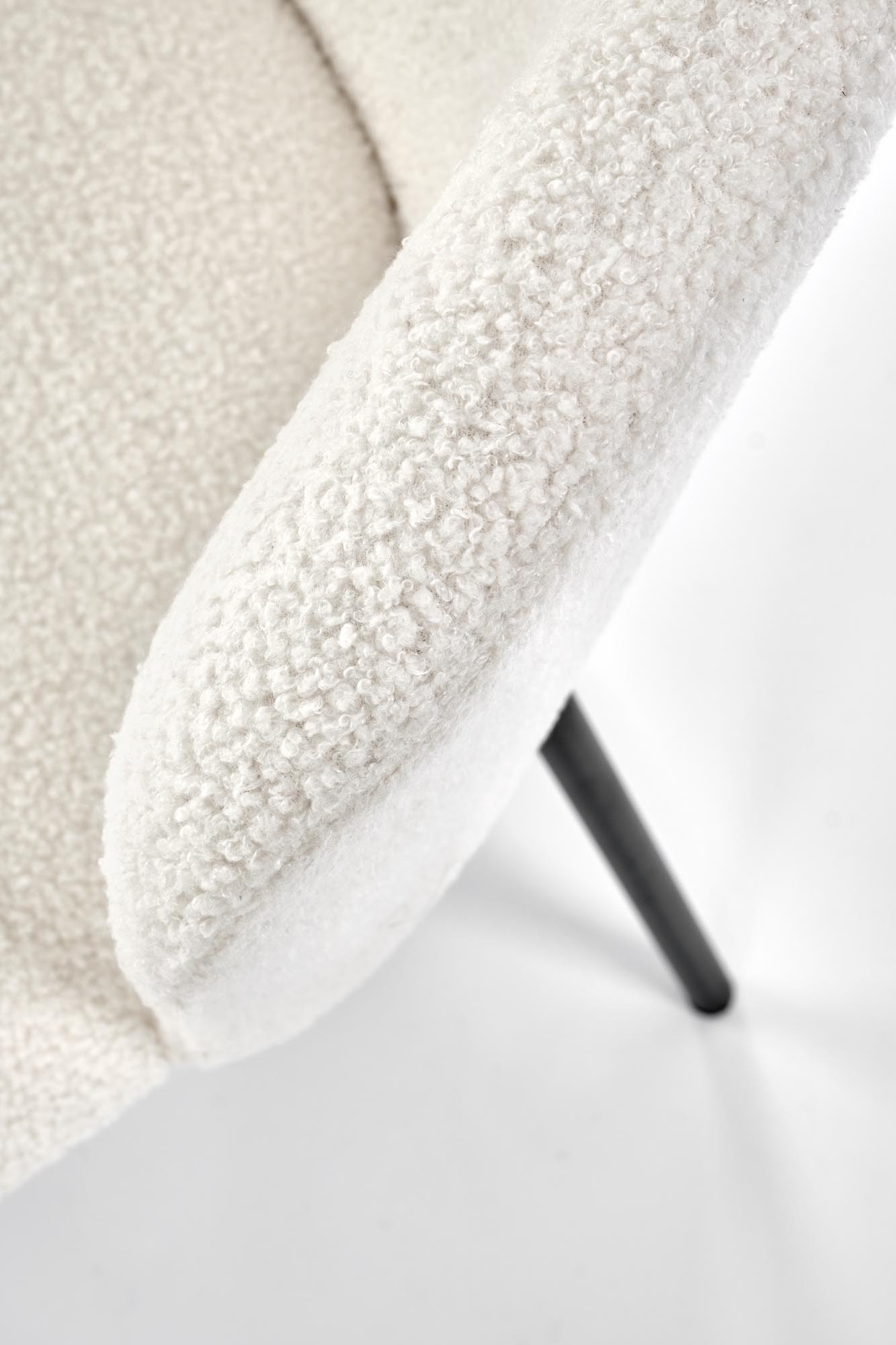 Zbliżenie na kremowe krzesło K518 z tkaniny boucle na czarnych metalowych nogach.