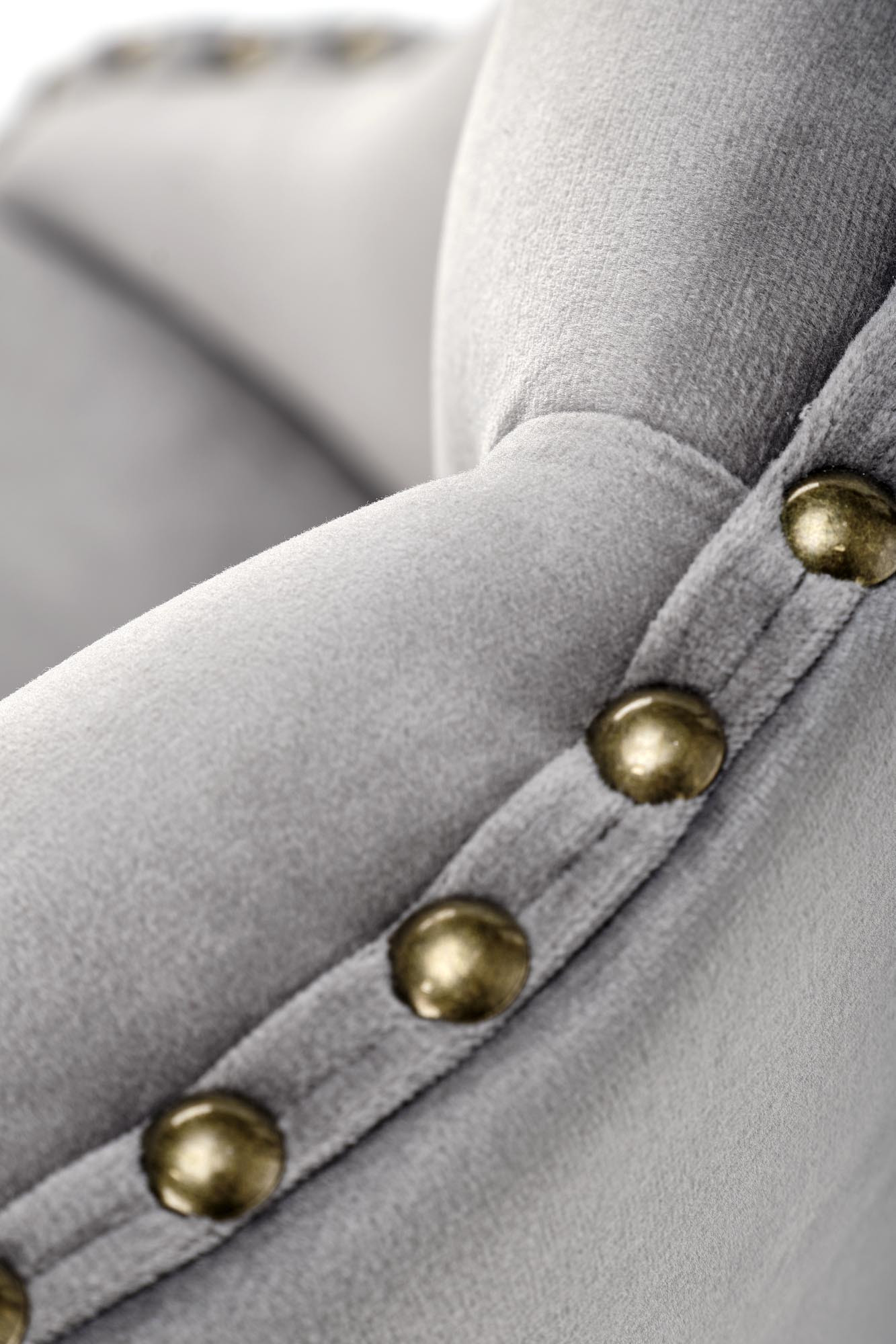 Zbliżenie na szare tapicerowane oparcie hokera H117 z ozdobnymi ćwiekami.