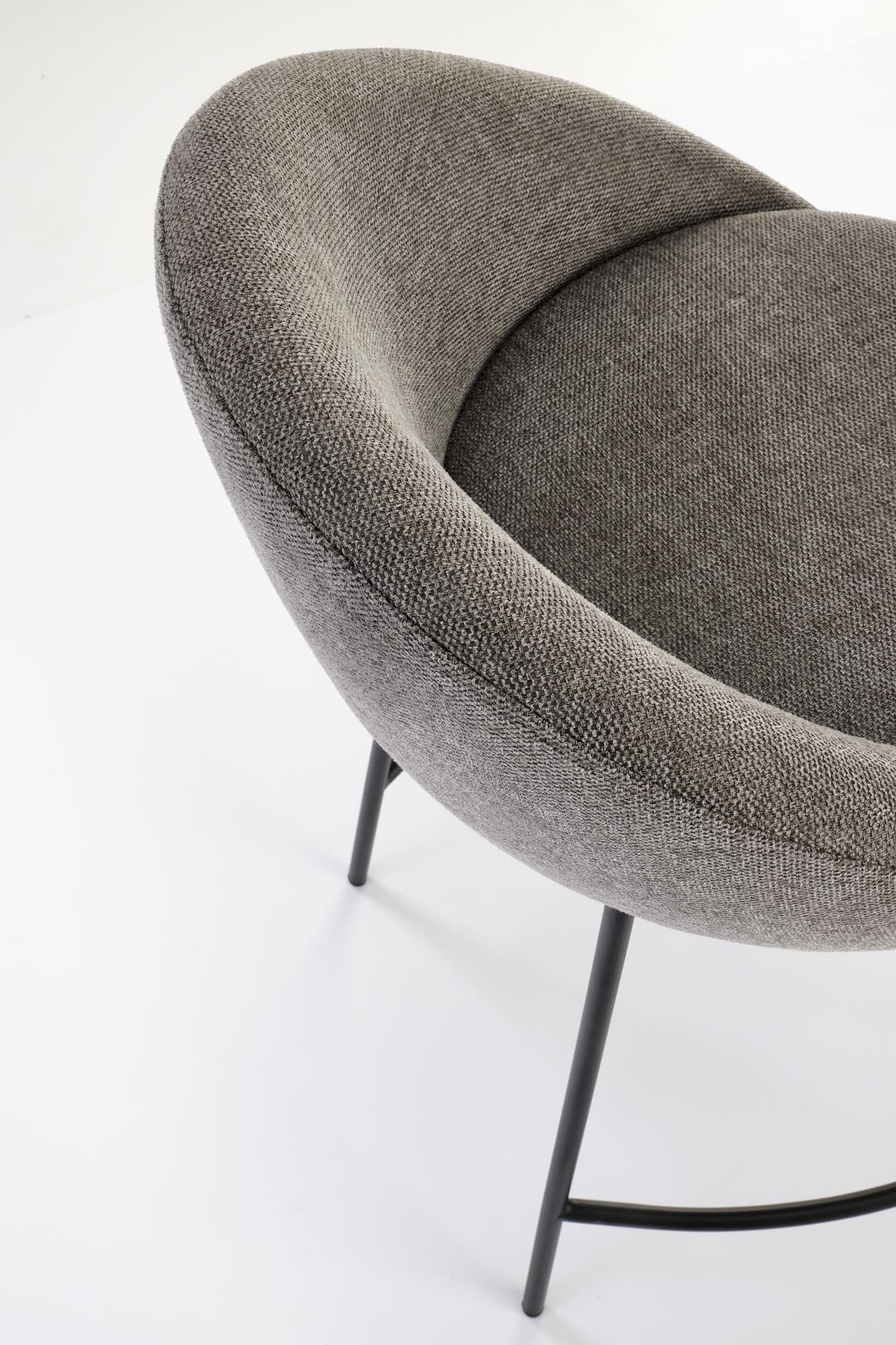 Zbliżenie na popielate, tapicerowane siedzisko hokera H118 z czarnymi metalowymi nogami.