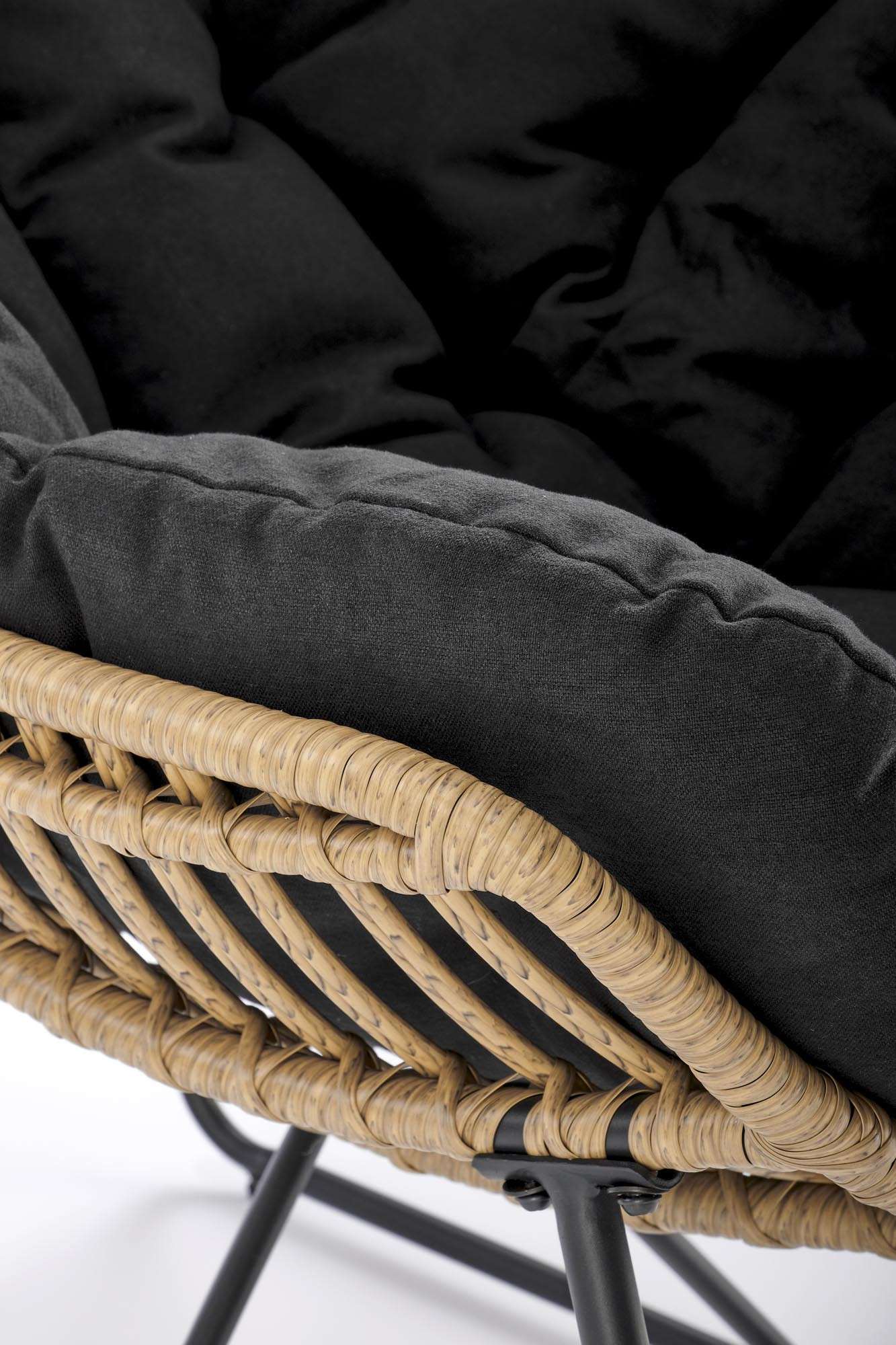 Zbliżenie na oparcie fotela WHISPER z czarnego sztucznego rattanu i metalowych nóg.