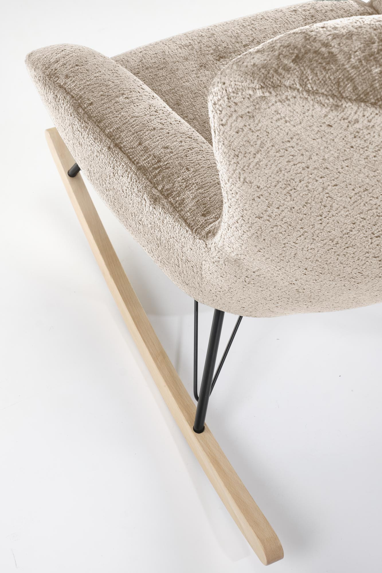 Zbliżenie na beżowy fotel bujany CASTRO z tkaniny, stalowe nogi i drewniane płozy.