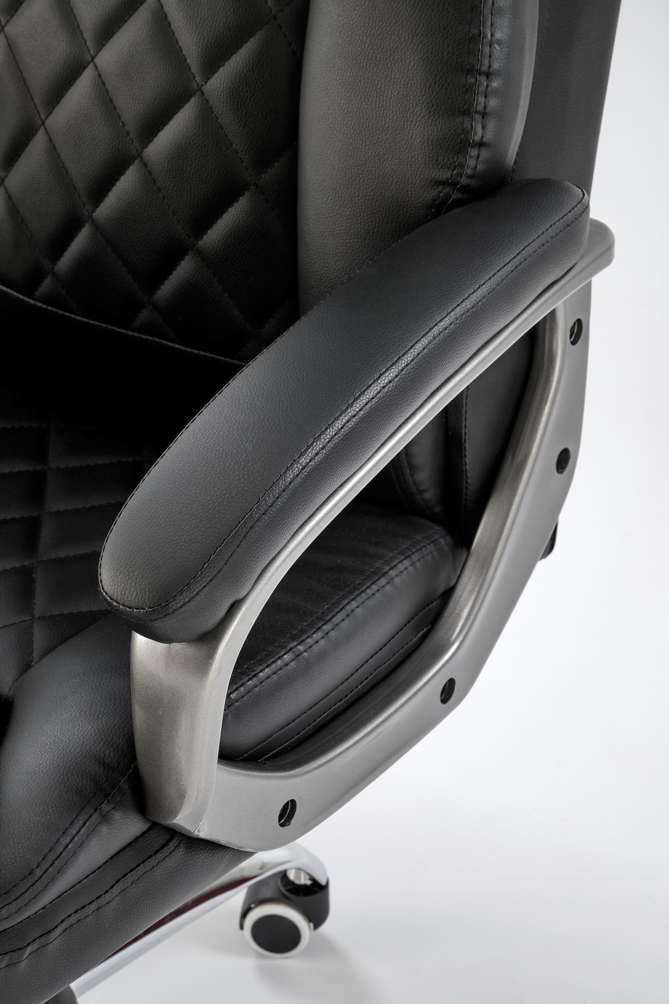 Zbliżenie na czarne pikowane oparcie i podłokietnik fotela biurowego HELDER z eco skóry.