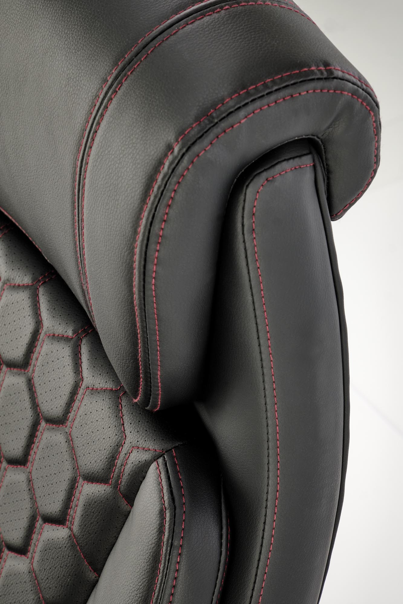 Zbliżenie na perforowaną eco skórę z eleganckim wzorem czarnego fotela gabinetowego THOMAS.