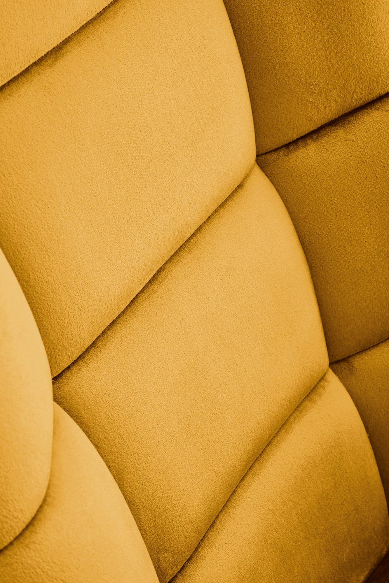 Zbliżenie na musztardowy velvetowy materiał fotela bujanego BAZALTO, pikowany.