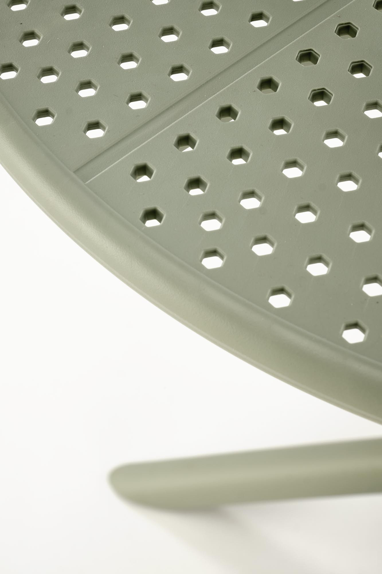 Zbliżenie na miętowy okrągły stół CALVO z polipropylenu z ażurowym blatem.