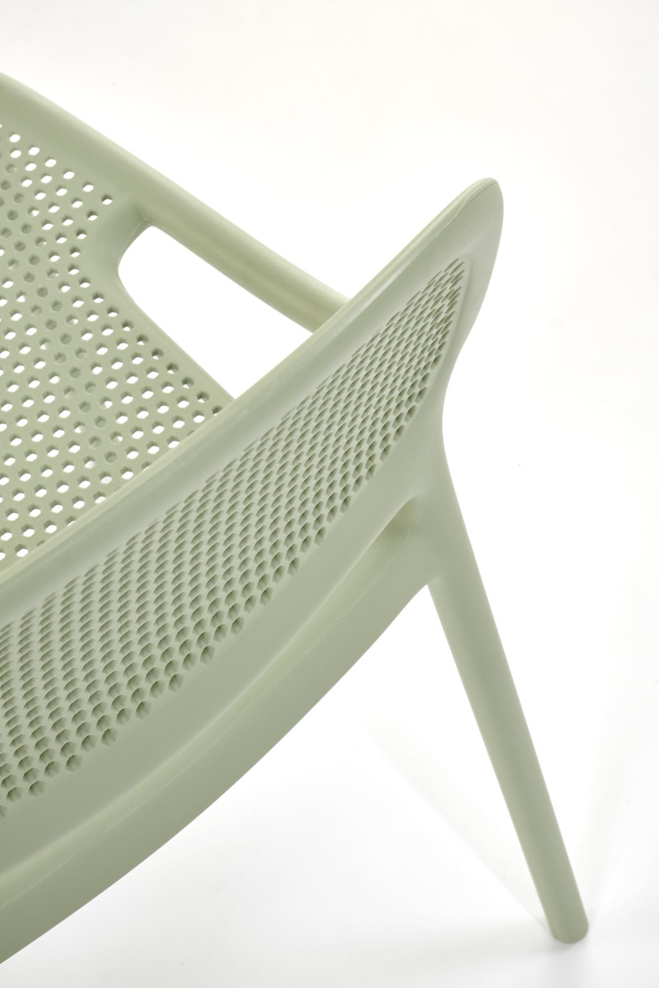 Zbliżenie na perforowane oparcie miętowego krzesła K532 z polipropylenu.
