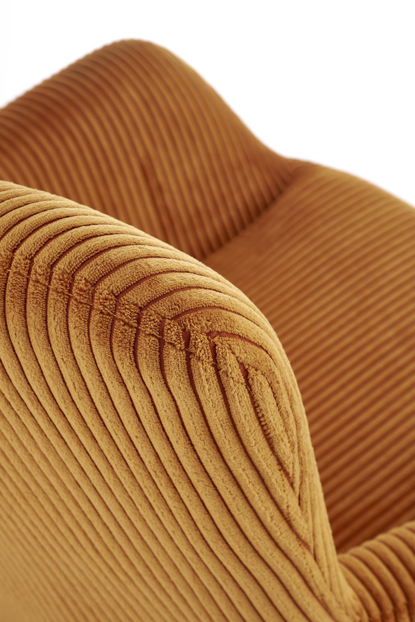 Zbliżenie na musztardowy sztruksowy materiał fotela wypoczynkowego AMARO.